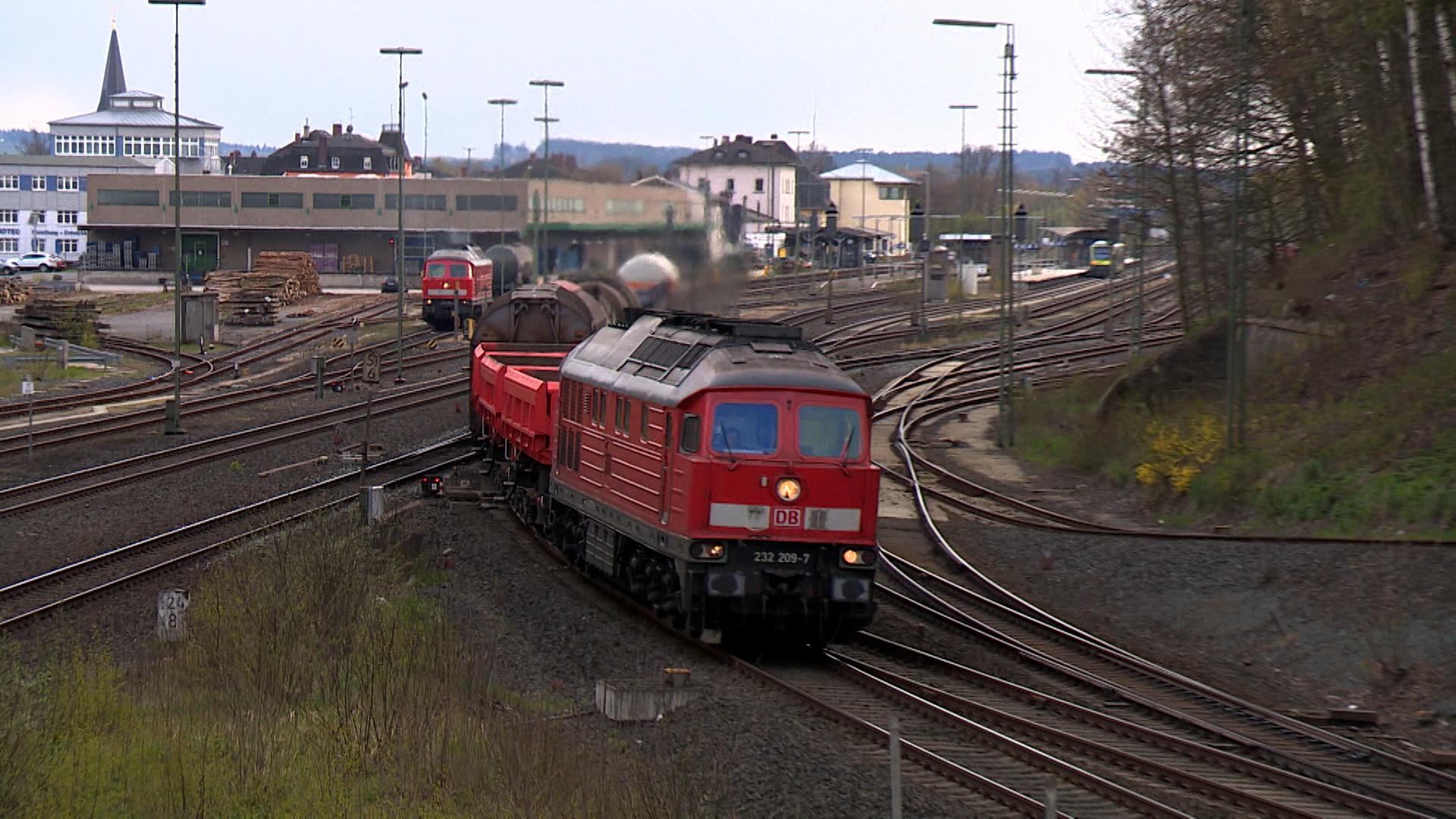 Eine Diesellok fährt auf Gleisen. 