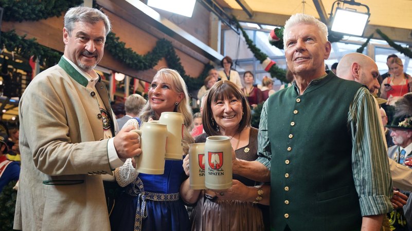 20.09.2025, Bayern, München: Markus Söder (CSU, l-r), Ministerpräsident von Bayern, mit seiner Frau Karin Baumüller-Söder, und Dieter Reiter (SPD, r), Oberbürgermeister von München, mit seiner Frau Petra, halten nach dem Anstich im Schottenhammel-Festzelt Bierkrüge. Die 190. Wiesn findet vom 20. September bis 05. Oktober 2025 auf der Münchner Theresienwiese statt. Foto: Peter Kneffel/dpa +++ dpa-Bildfunk +++ | Bild: Peter Kneffel/dpa 20.09.2025, Bayern, München: Markus Söder (CSU, l-r), Ministerpräsident von Bayern, mit seiner Frau Karin Baumüller-Söder, und Dieter Reiter (SPD, r), Oberbürgermeister von München, mit seiner Frau Petra, halten nach dem Anstich im Schottenhammel-Festzelt Bierkrüge. Die 190. Wiesn findet vom 20. September bis 05. Oktober 2025 auf der Münchner Theresienwiese statt. Foto: Peter Kneffel/dpa +++ dpa-Bildfunk +++