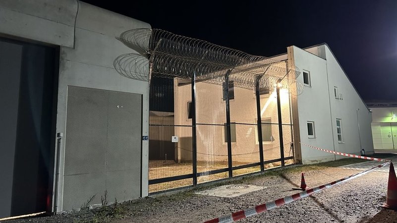 Ein Absperrband flattert vor dem Hochsicherheitstor am Bezirkskrankenhaus Straubing. | Bild: BR/Andreas Wenleder Ein Absperrband flattert vor dem Hochsicherheitstor am Bezirkskrankenhaus Straubing.