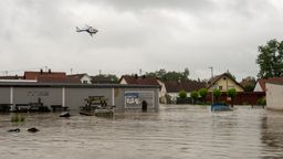 Ein Polizeihubschrauber fliegt über einem überfluteten Wohngebiet in Babenhausen. Nach den ergiebigen Regenfällen der letzten Tage gibt es Hochwasser in der Region. | Bild:picture alliance/dpa | Stefan Puchner