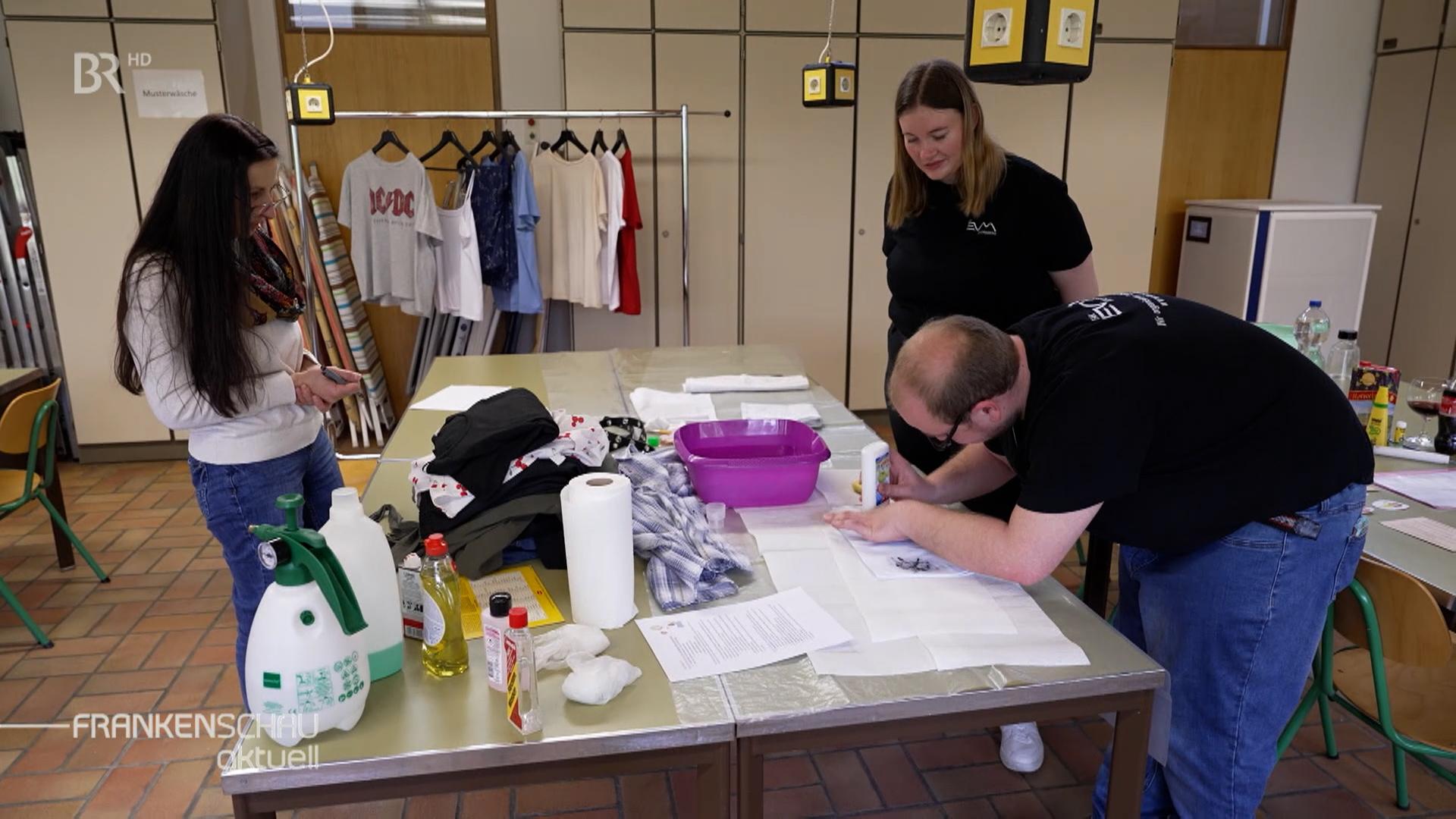 Zwei Schülerinnen und ein Lehrer in einer Hauswirtschaftsschule in Ahornberg.