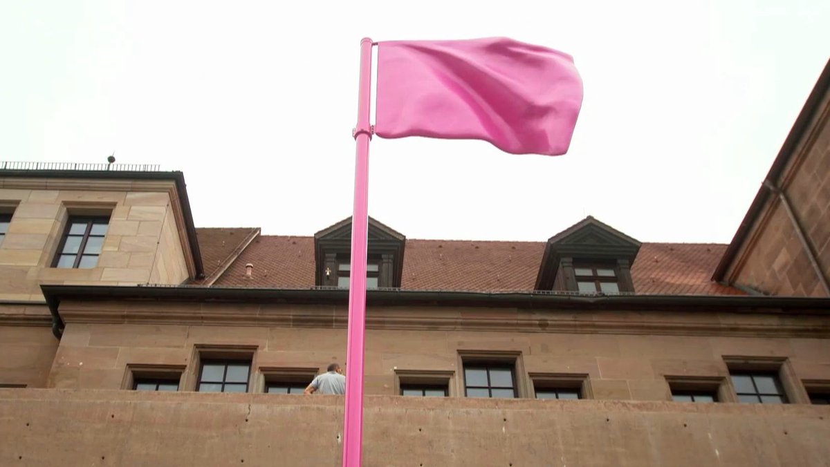 Vor dem Eingang steht das neue Emblem des Künstlerhauses: eine rosarote Fahne aus Stahl.