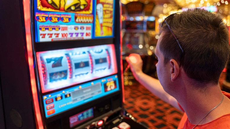 Ein junger Mann spielt an einem Spielautomaten in einem Casino, aufgenommen im Juli 2023 | Bild:picture alliance / CHROMORANGE | Michael Bihlmayer