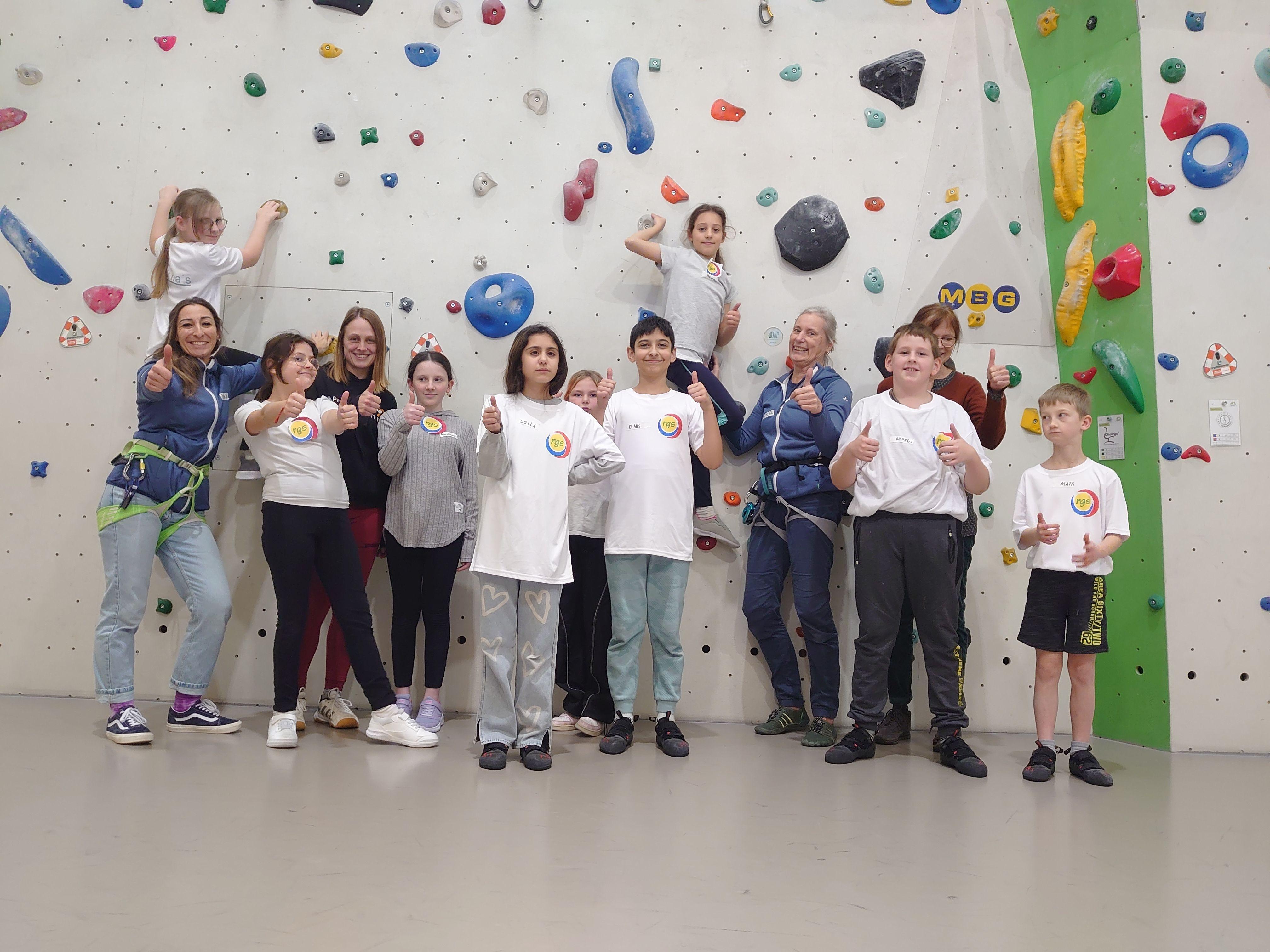 Neun Schülerinnen und Schüler stehen mit ihren beiden Lehrerinnen und zwei Kletter-Betreuerinnen in der Halle der DAV Sektion Hersbruck.