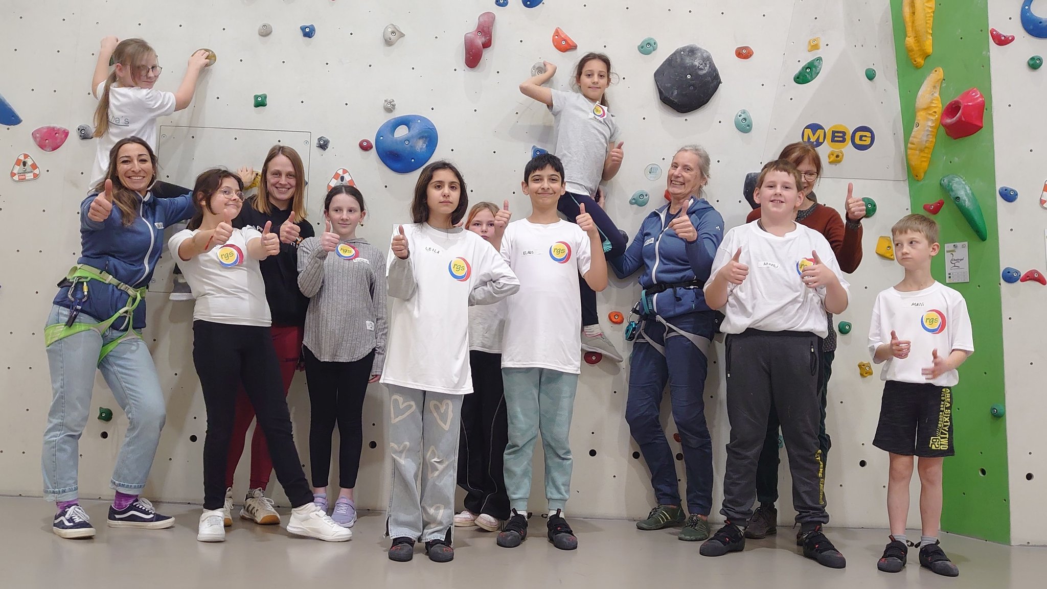 Neun Schülerinnen und Schüler stehen mit ihren beiden Lehrerinnen und zwei Kletter-Betreuerinnen in der Halle der DAV Sektion Hersbruck.