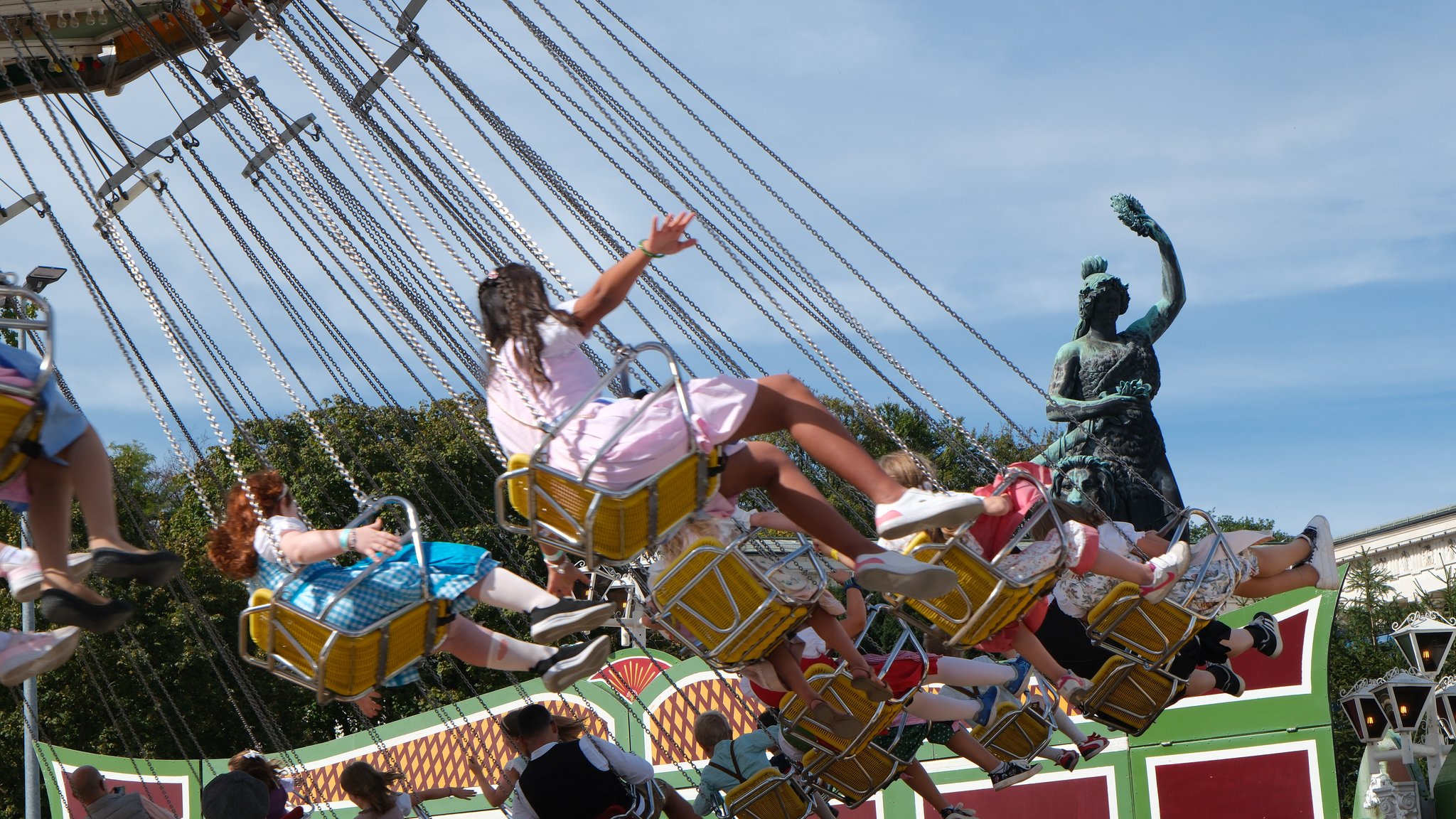 Menschen im Kettenkarussell, im Hintergrund die Bavaria-Statue auf der Theresienwiese. Schönes Wetter, viele Gäste, wenige Probleme: So lief das erste Wiesn-Wochenende. | Bild: picture alliance / ZUMAPRESS.com | Julius Mortsi Menschen im Kettenkarussell, im Hintergrund die Bavaria-Statue auf der Theresienwiese. Schönes Wetter, viele Gäste, wenige Probleme: So lief das erste Wiesn-Wochenende.