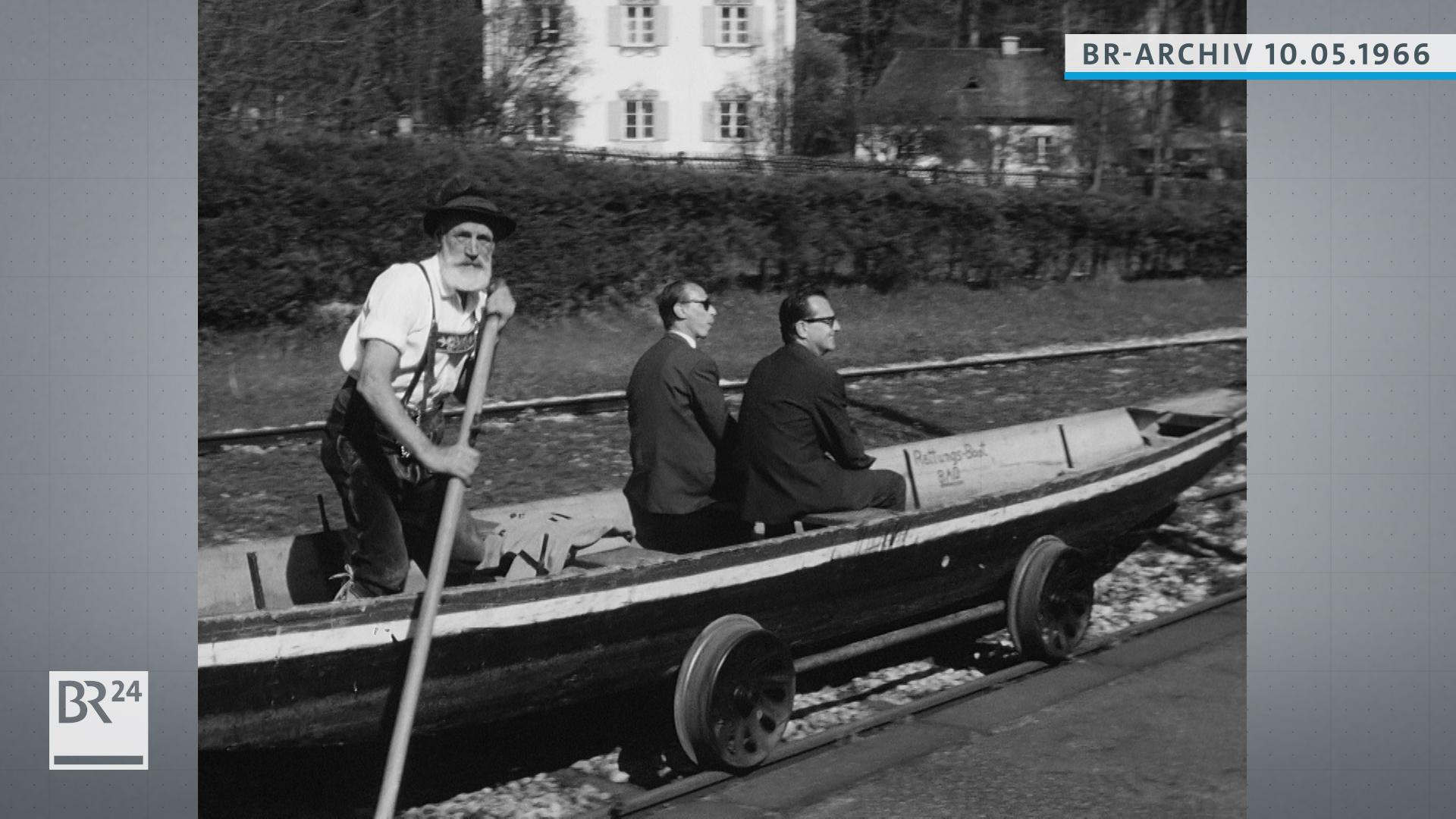 Bootfahrer transportiert Passagiere in einem Boot, das auf Bahngleisen rollt