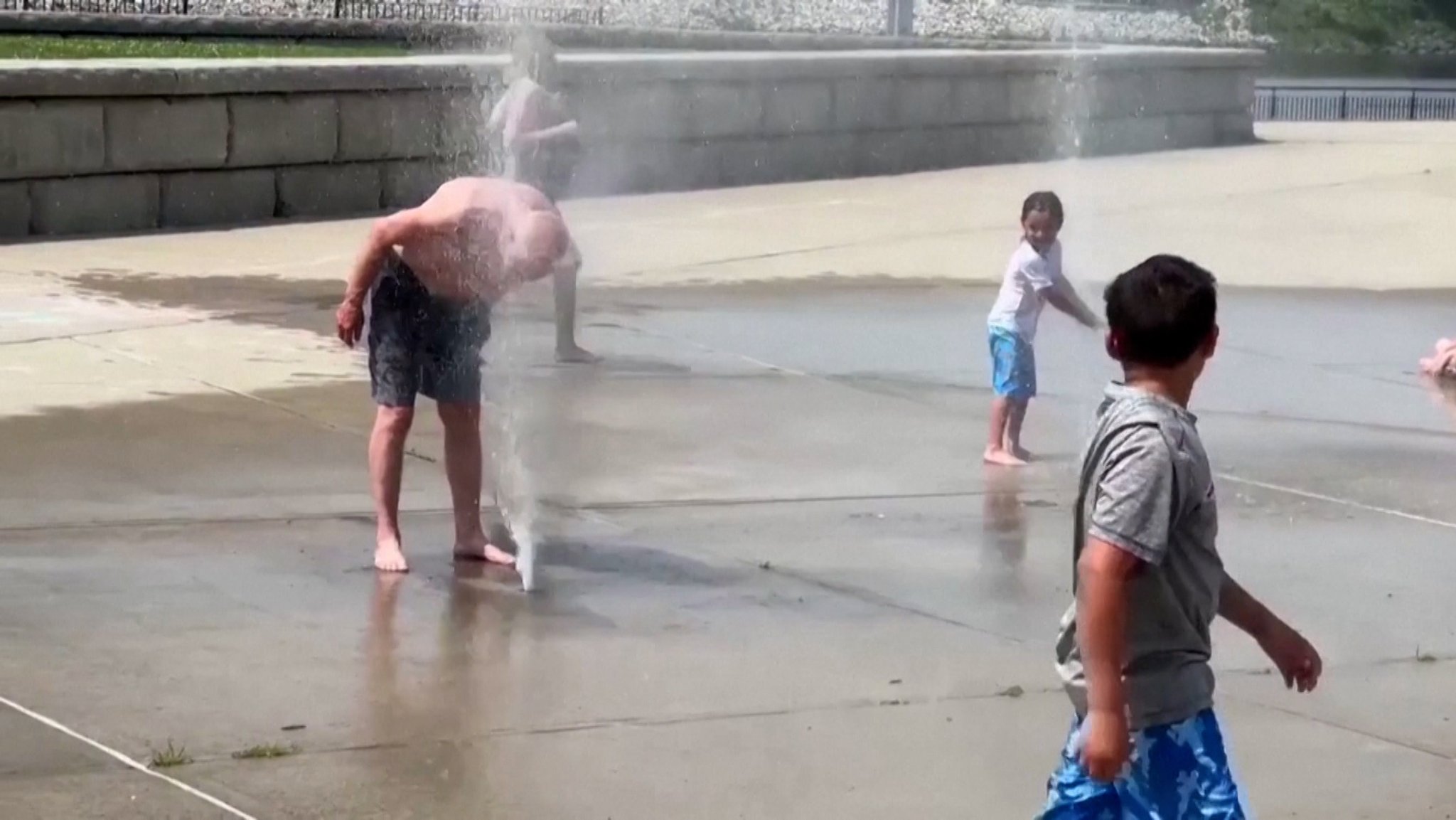 Menschen suchen in einem Springbrunnen Abkühlung