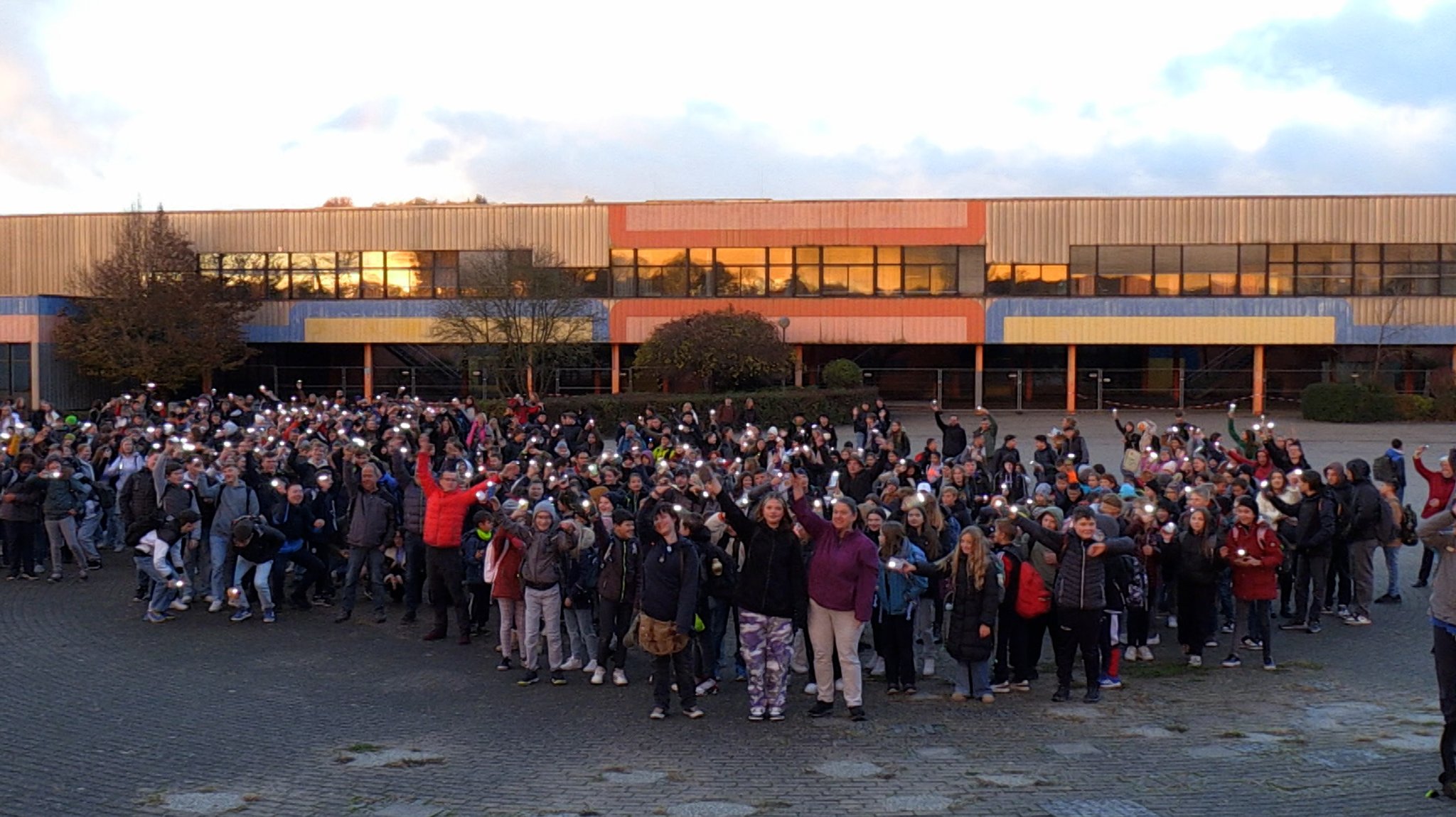 Schülerinnen und Schüler leuchten mit Taschenlampen vor der Senefelder-Schule in Treuchtlingen