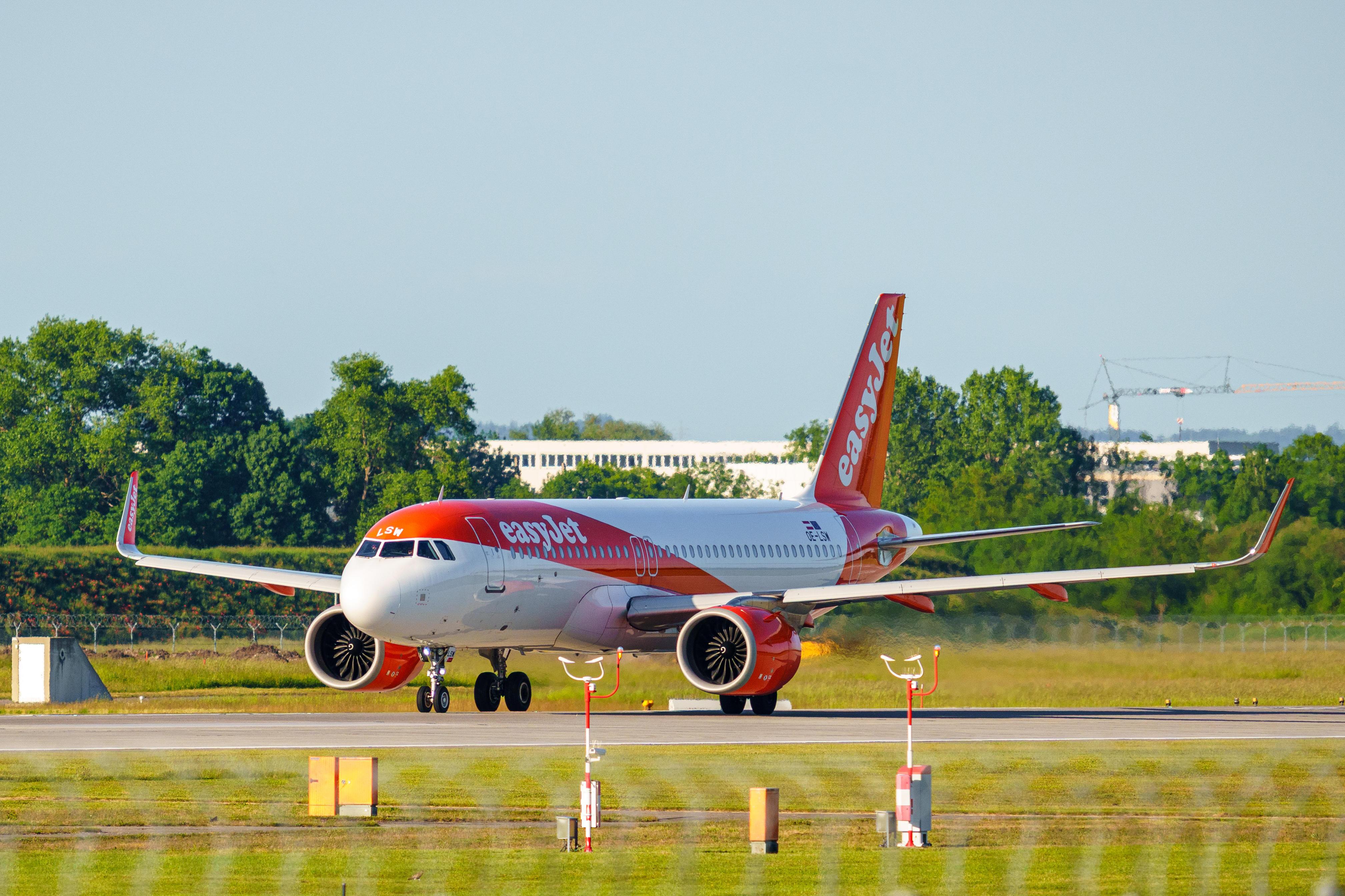 Ein Airbus A320neo der britischen Fluggesellschaft easyJet rollt bei Sonnenschein über das Vorfeld des Münchner Flughafens (ARCHIVBILD)