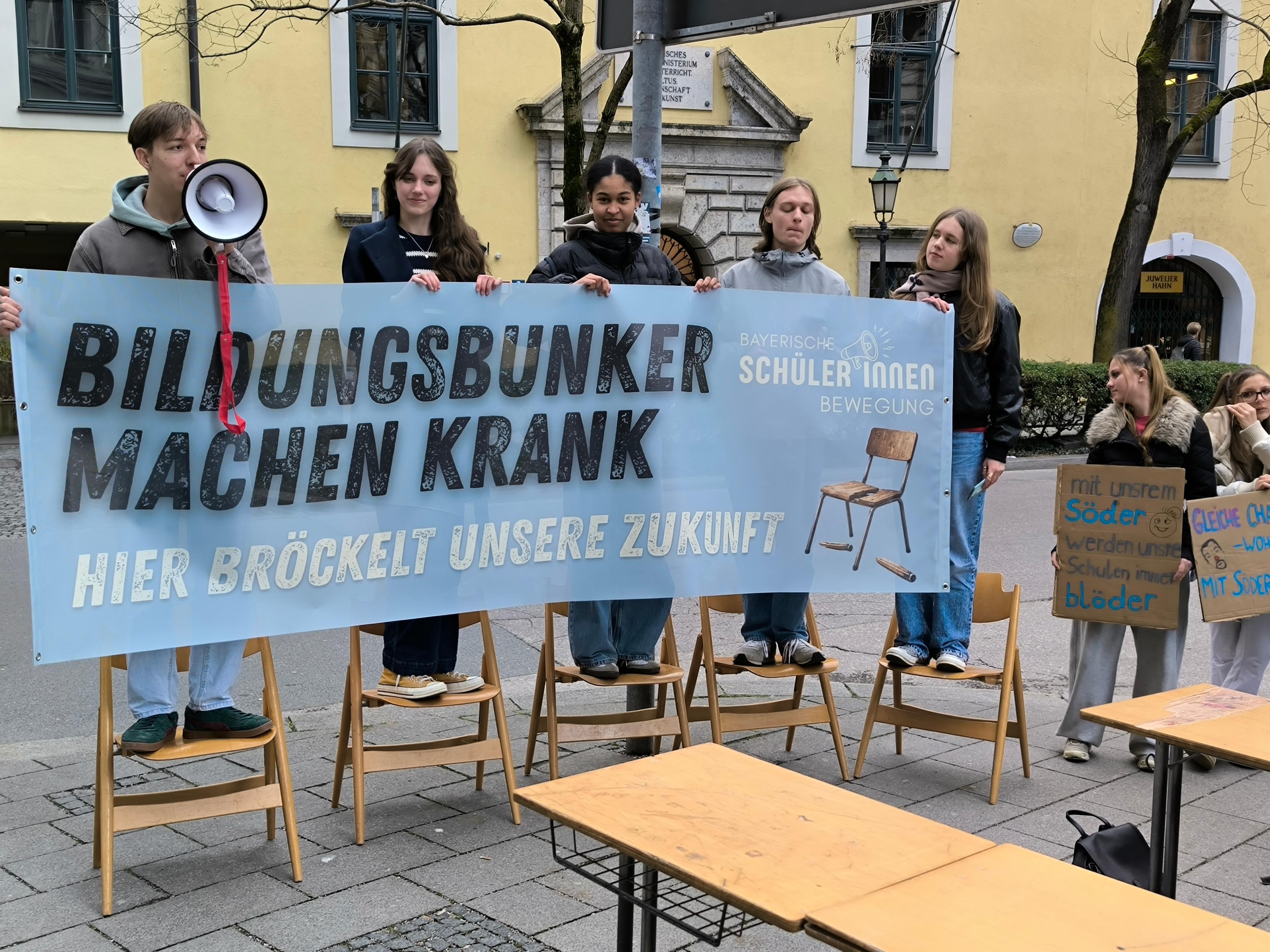 Fünf Schüler halten ein Transparent mit der Aufschrift: Bildungsbunker machen krank