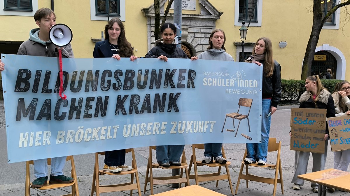 Fünf Schüler halten ein Transparent mit der Aufschrift: Bildungsbunker machen krank