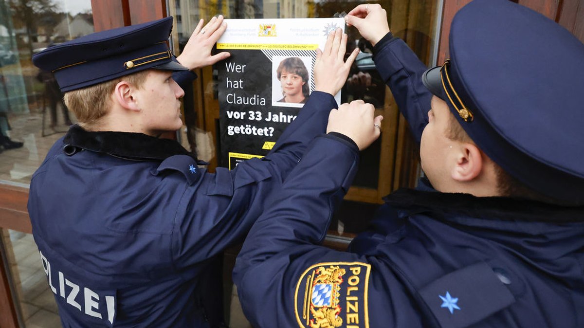  Polizisten hängen das Plakat zum Cold-Case von Claudia Obermeier auf