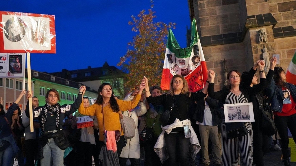 Iranische Frauen mit grün-weiß-roten Flaggen bei einer Demonstration in Nürnberg