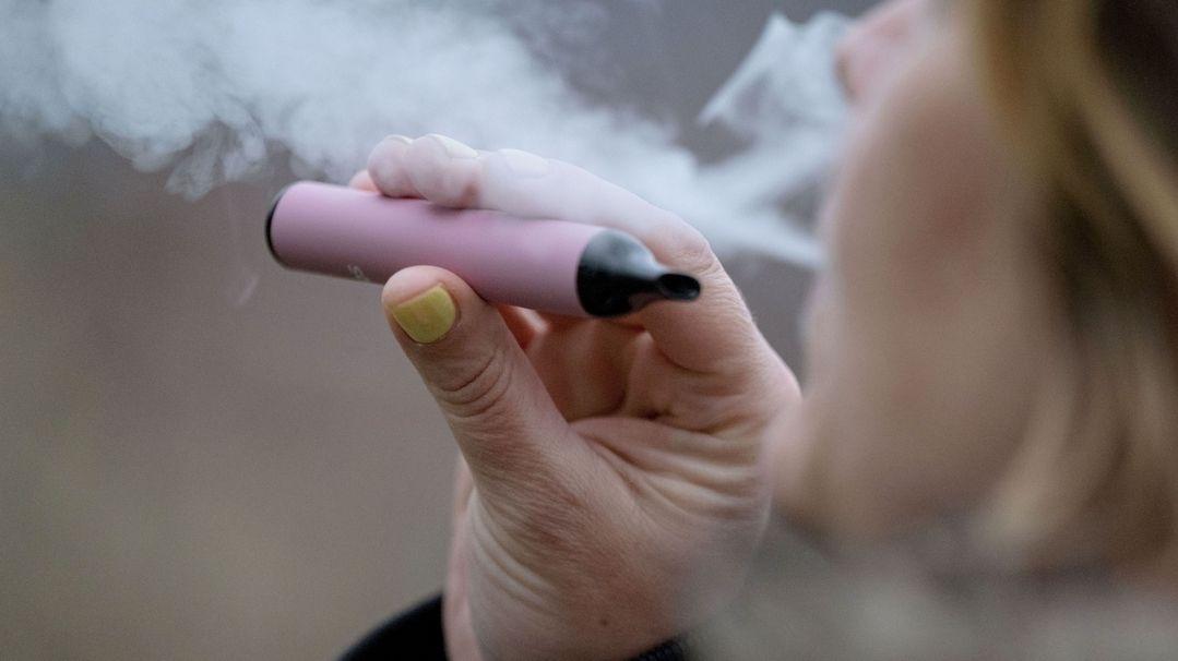 (Symbolbild) Eine Frau raucht eine elektronische Zigarette (Vape). 