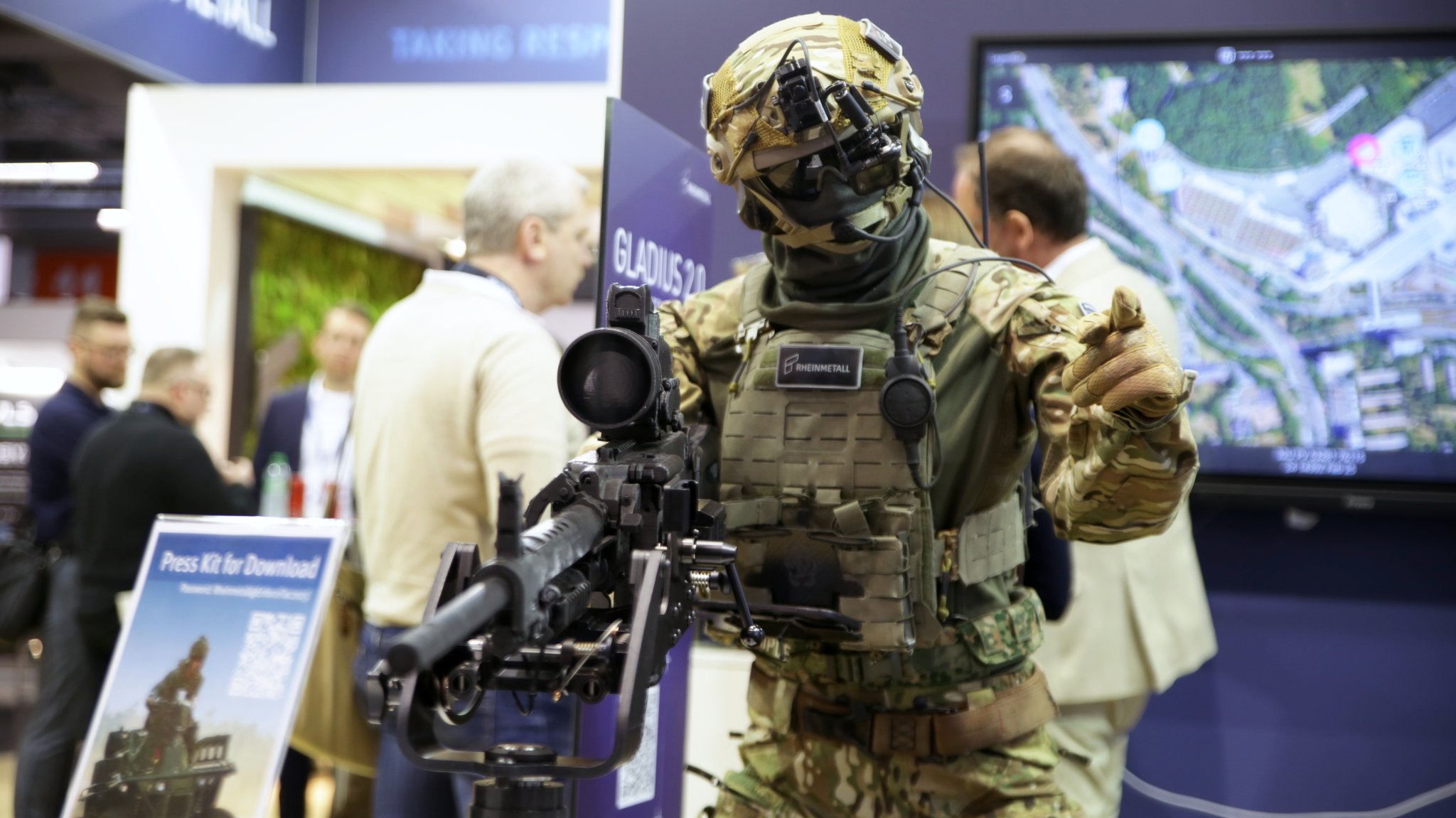 Ein Soldat steht an einem Gewehr. Auf der Enforce Tac sind Schutzausrüstungen und Waffen frei ausgestellt. 