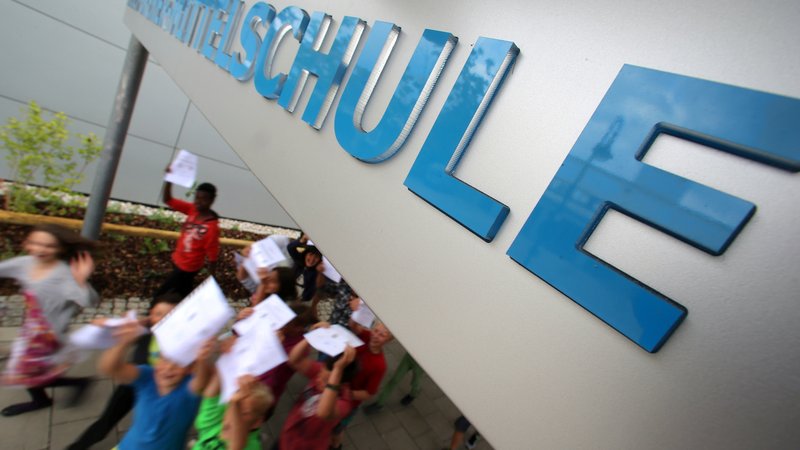 Schülerinnen und Schüler laufen mit ihren Zeugnisses aus der Schule | Bild: picture alliance / dpa | Stephan Jansen Schülerinnen und Schüler laufen mit ihren Zeugnisses aus der Schule