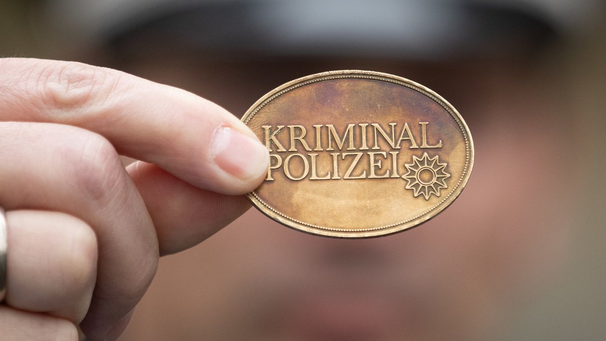 Falscher Polizist zeigt Polizeimarke (Symbolbild).