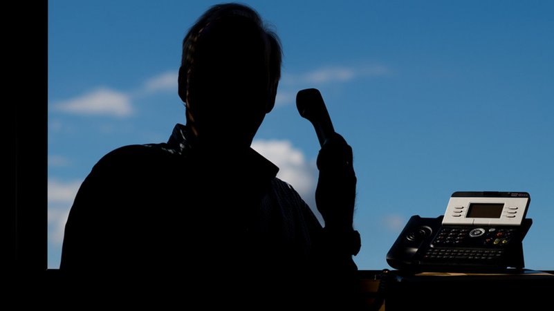 Ein Mann im Gegenlicht telefoniert. | Bild: dpa-Bildfunk/Julian Stratenschulte Ein Mann im Gegenlicht telefoniert.