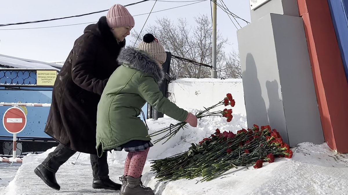 Menschen legen Blumen zum Gedenken an die Opfer des Flugzeugabsturzes nieder