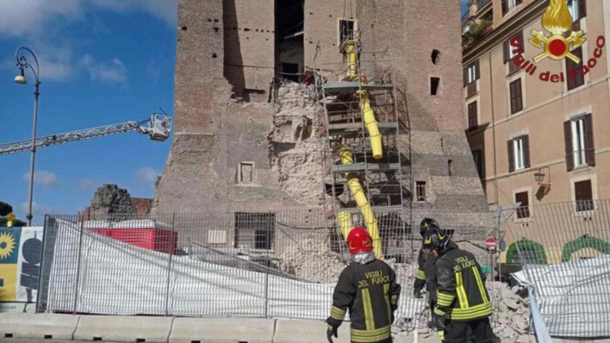 Italienische Feuerwehrleute stehen vor dem zum Teil eingestürzten Torre dei Conti in Rom. | Bild: picture alliance / ROPI | VVFF Italienische Feuerwehrleute stehen vor dem zum Teil eingestürzten Torre dei Conti in Rom.
