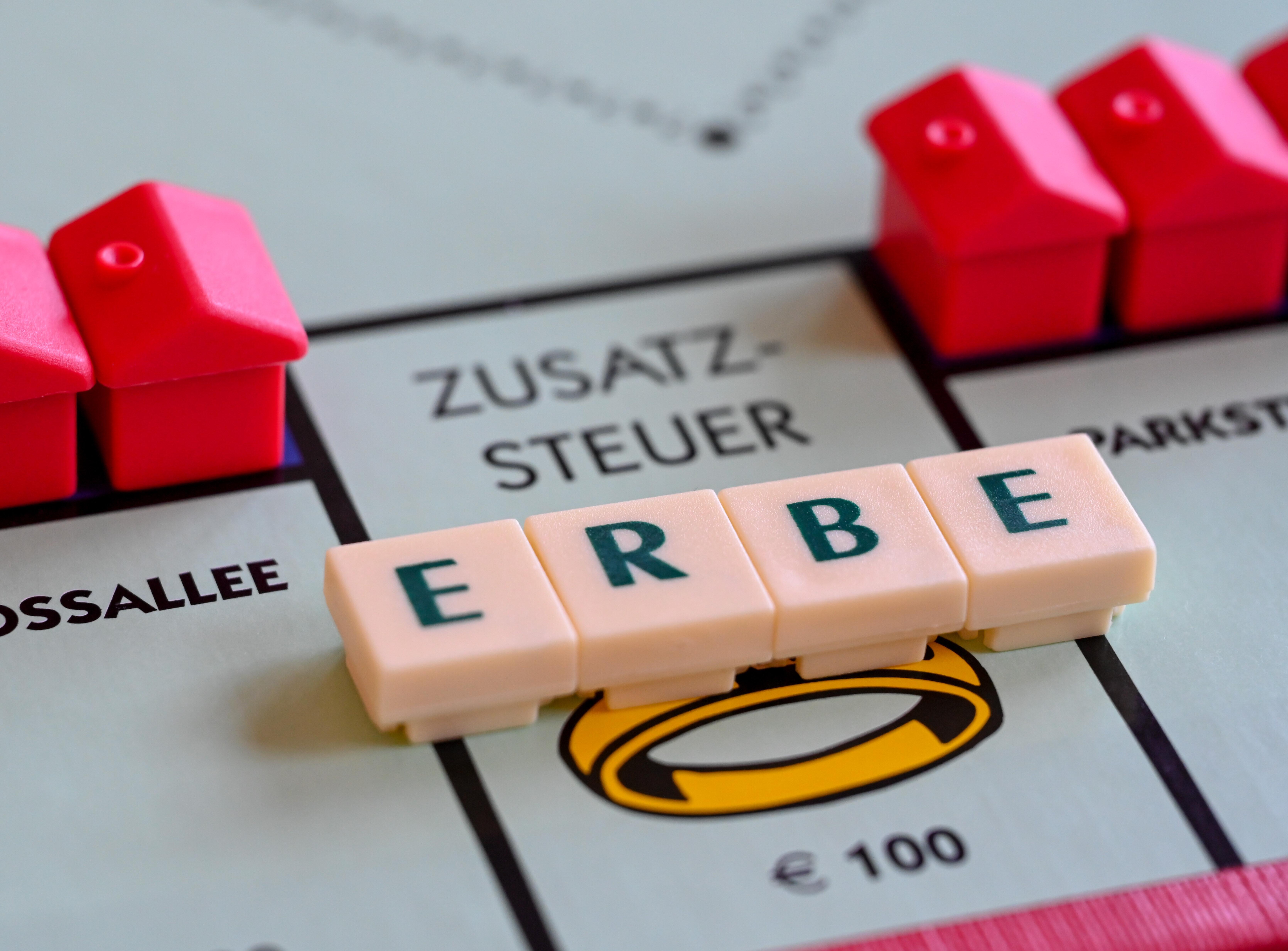 Beim Erben wird Erbschaftssteuer fällig. Scrabble-Steine mit dem Wort "Erbe" liegen auf einem Monopoly-Feld.