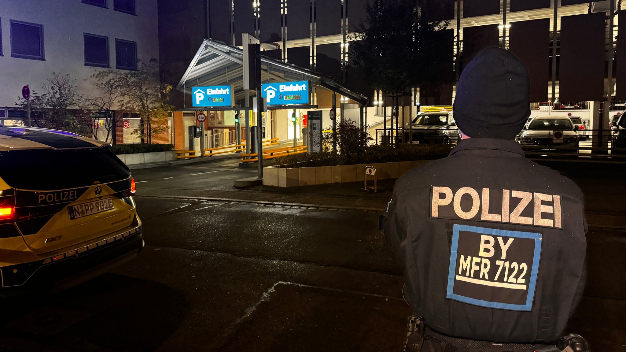 Polizist steht vor dem Parkhaus.