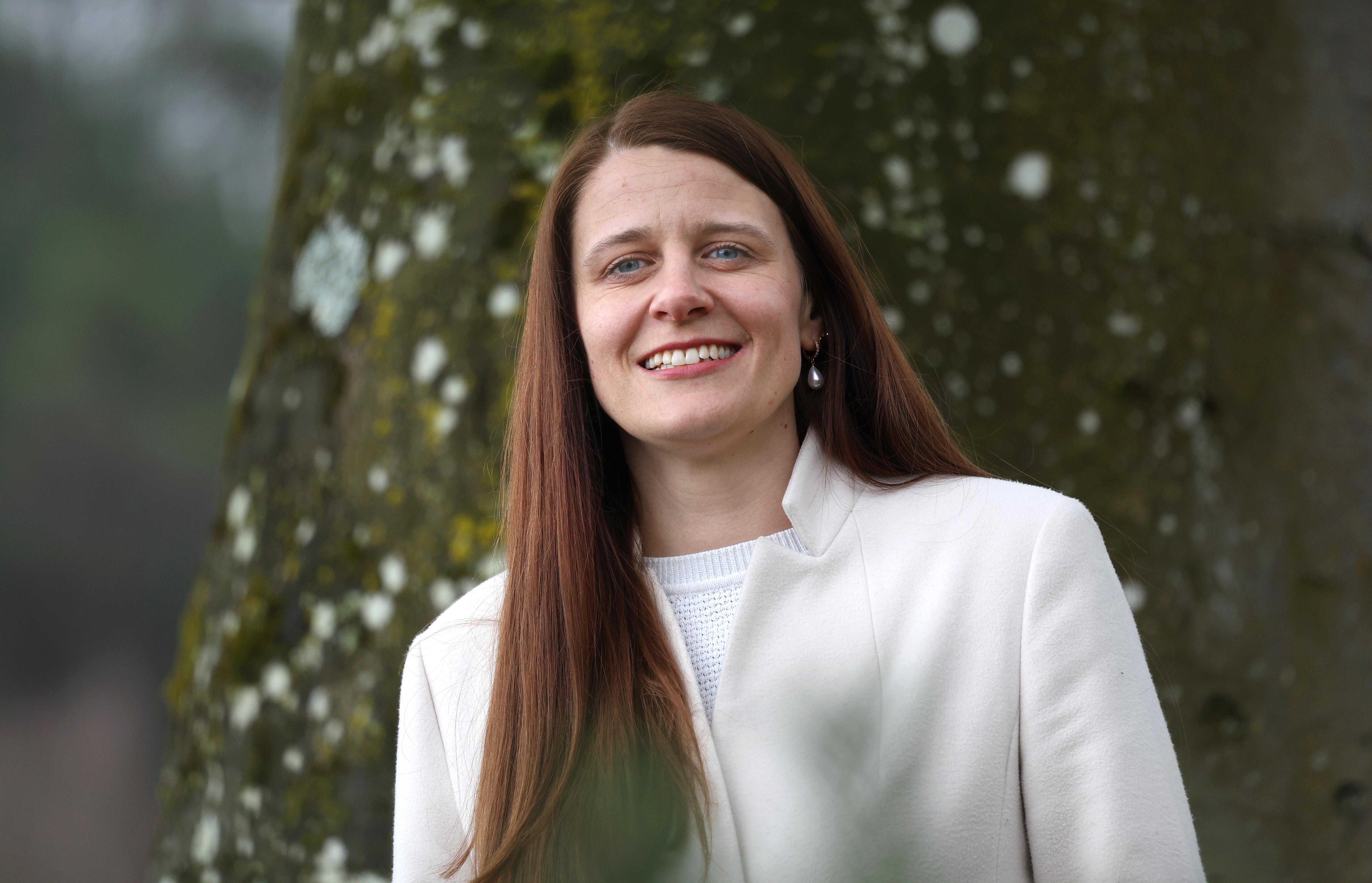 Daniela Groß steht in weißem Blazer vor einem Baum und lächelt in die Kamera. (Archivbild vom 17.3.)