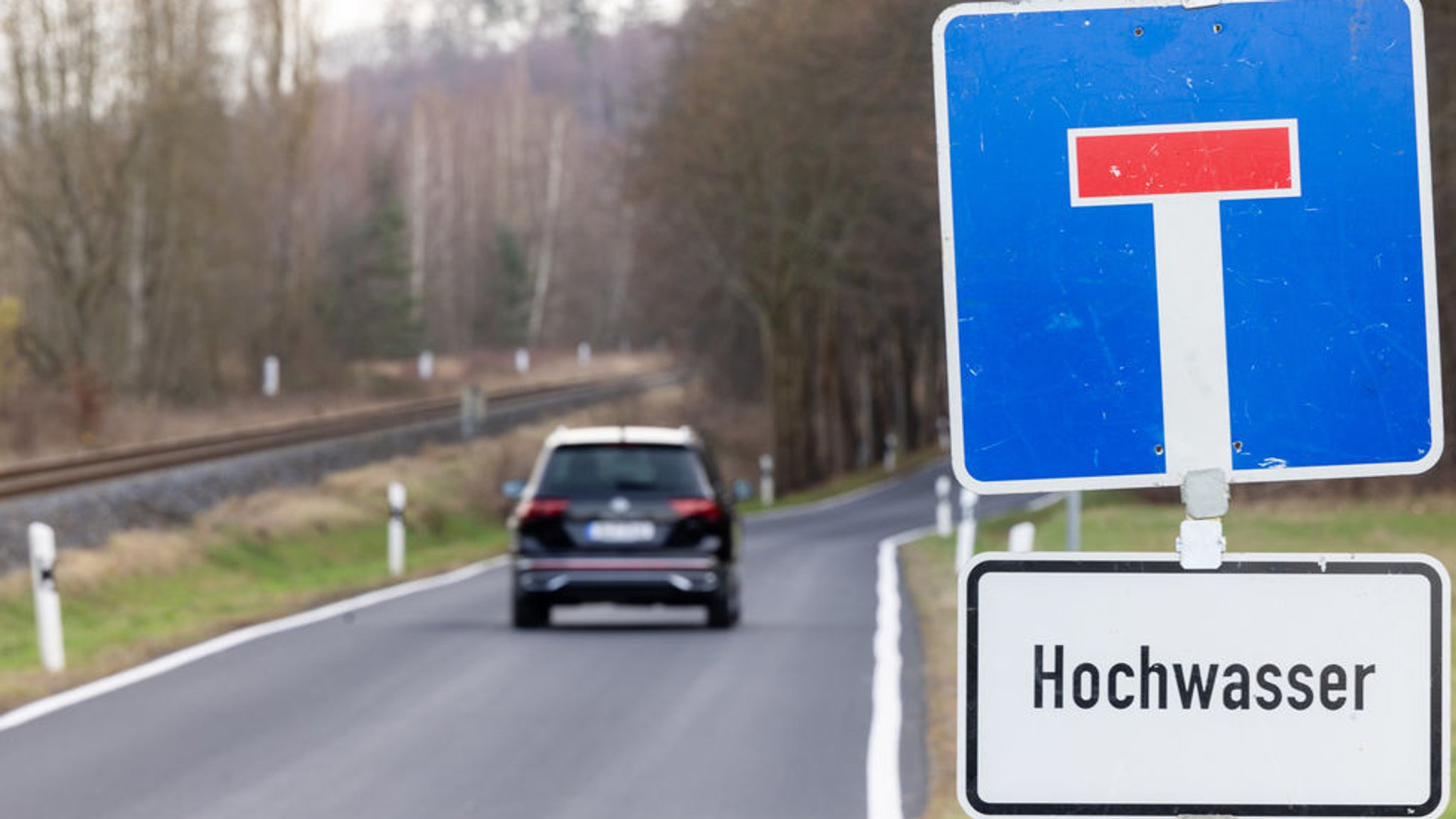 Ein Verkehrsschild weist auf  eine wegen Hochwasser gesperrte Nebenstraße hin. 