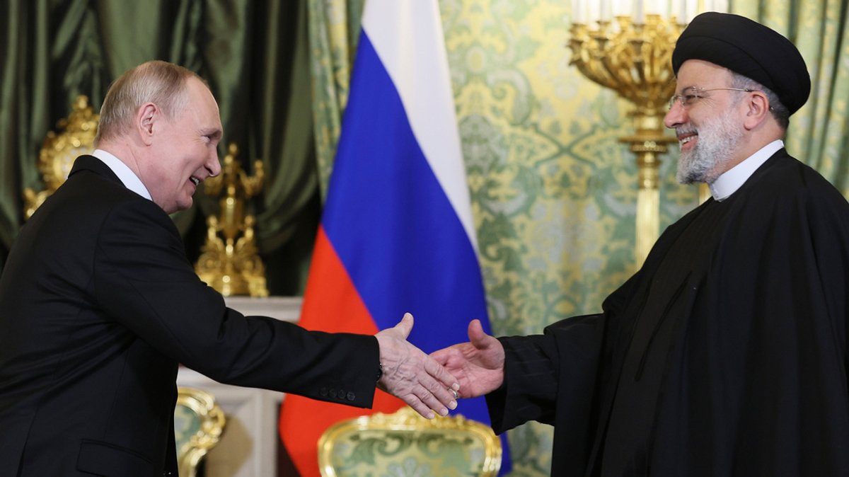Auf diesem von der staatlichen russischen Nachrichtenagentur Sputnik via AP veröffentlichten Foto gibt Wladimir Putin (l), Präsident von Russland, Ebrahim Raisi, Präsident des Iran, während ihres Treffens im Kreml die Hand.