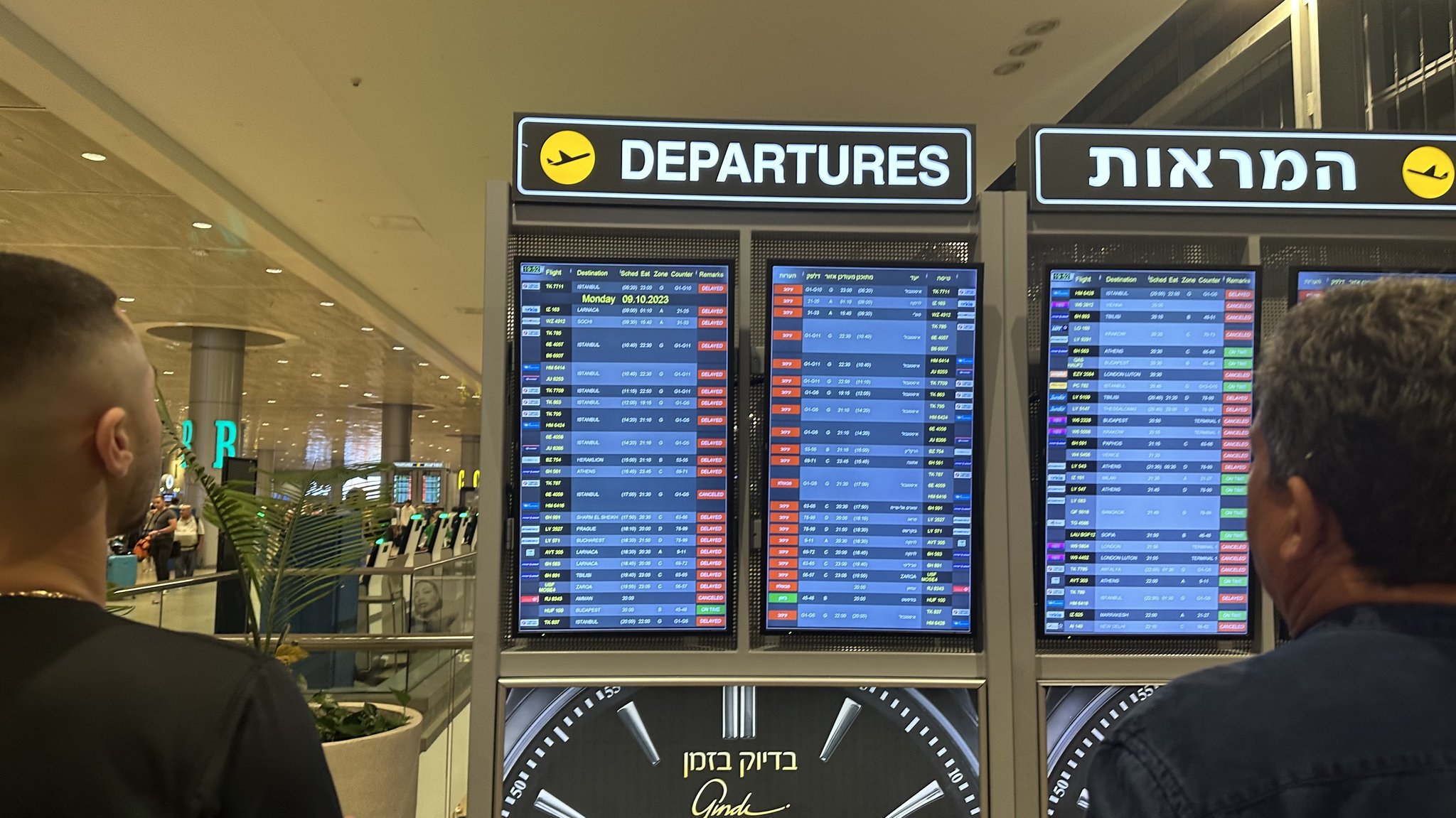 Zwei Männer schauen auf eine Anzeigentafel am Flughafen in Tel Aviv, der viele gecancelte Flüge anzeigt. (Archivbild vom 8.10.)