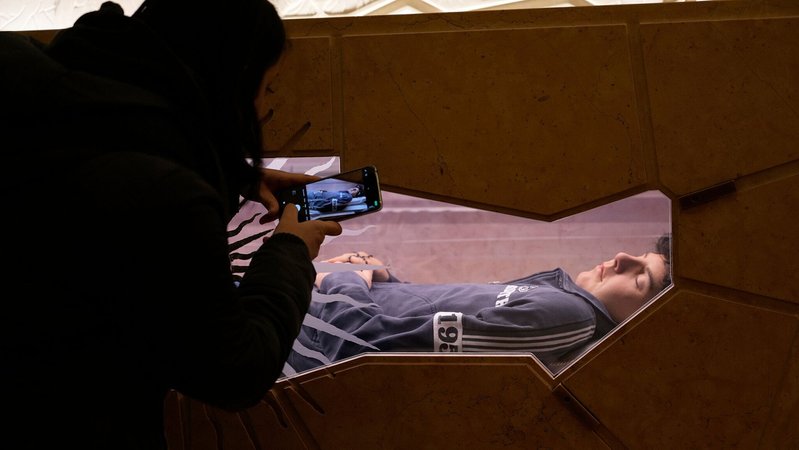 Ein Jugendlicher macht mit seinem Smartphone ein Foto am Grab des 15-jährigen Carlo Acutis. | Bild: picture alliance / ASSOCIATED PRESS | Gregorio Borgia Ein Jugendlicher macht mit seinem Smartphone ein Foto am Grab des 15-jährigen Carlo Acutis.