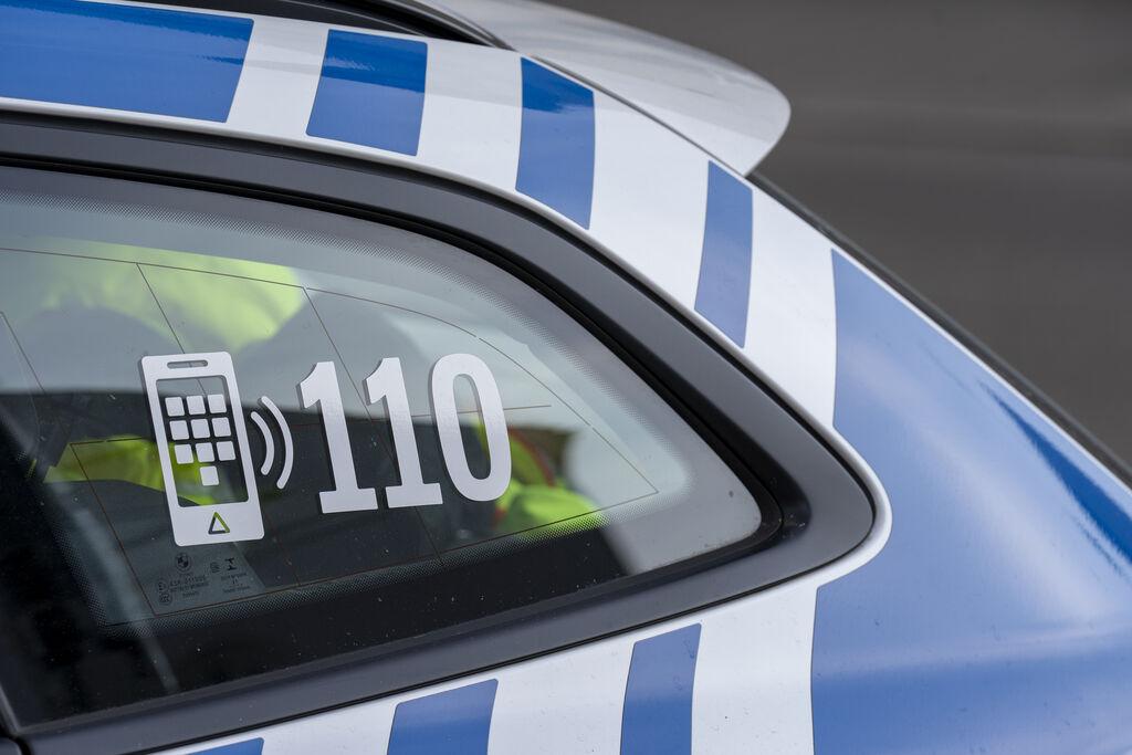 Die Notrufnummer 110 auf der Scheibe eines Polizeiautos.