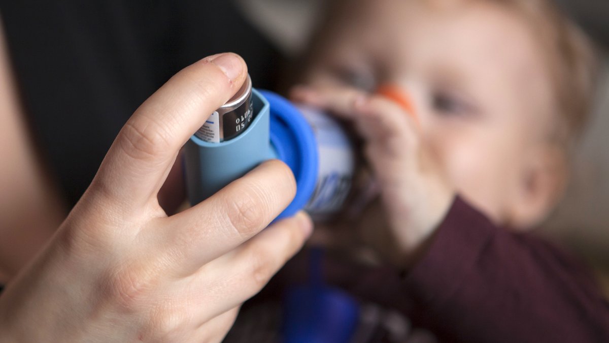 Ein Baby mit Asthma muss ein Asthma-Spray inhalieren. 
