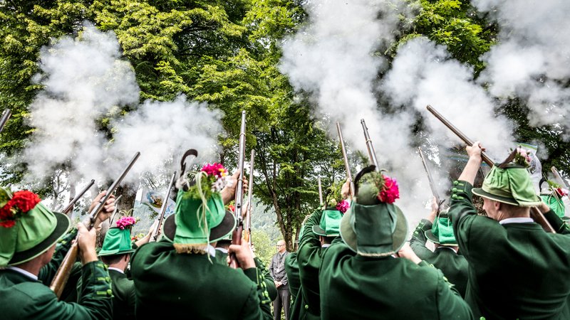 Männer in grüner Kleidung schießen mit Gewehren in die Luft. | Bild: Bild: picture alliance / SZ Photo | Sebastian Beck Männer in grüner Kleidung schießen mit Gewehren in die Luft.