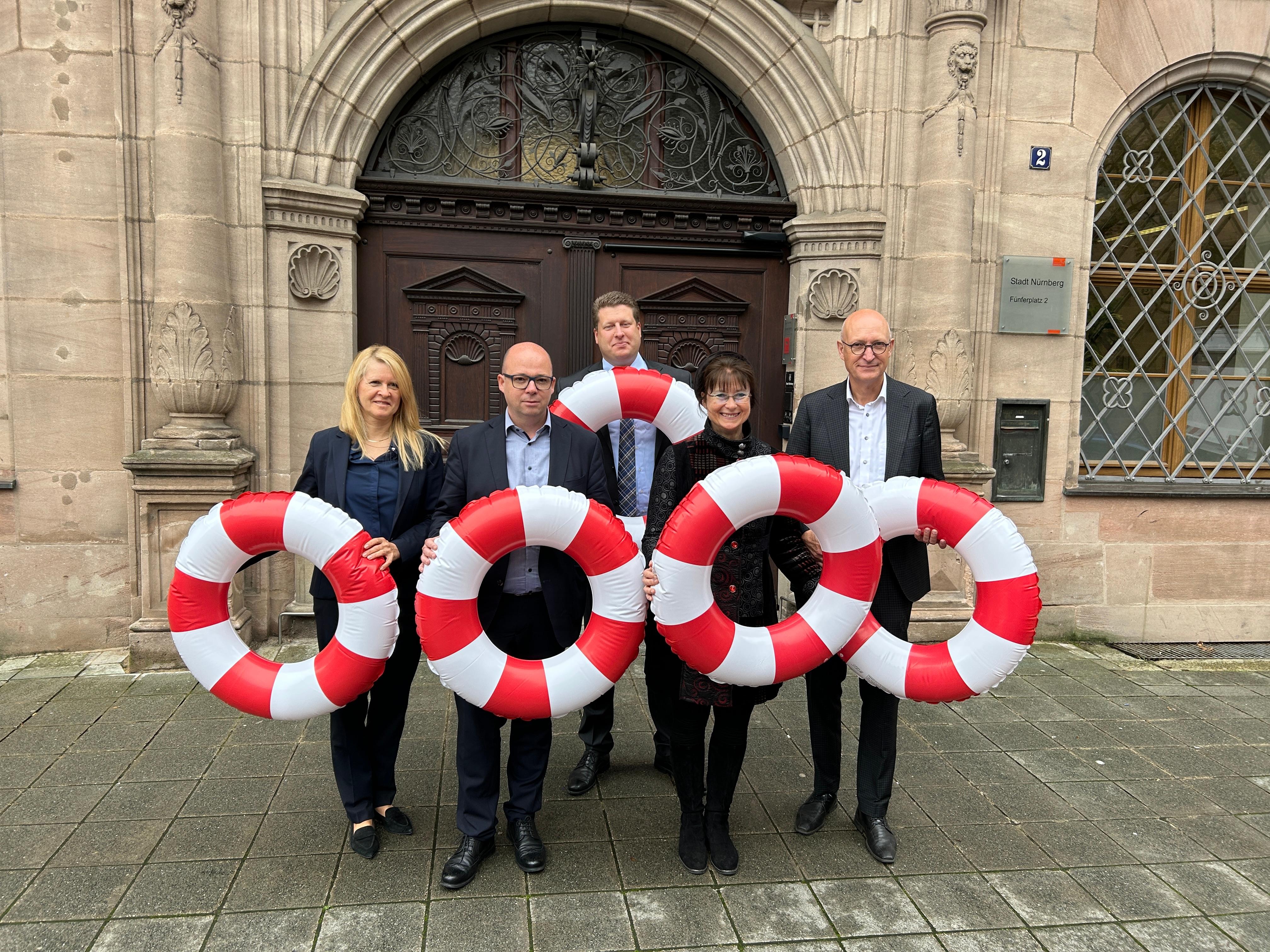 Die Kämmerer von Schwabach, Nürnberg, Ansbach, Fürth und Erlangen halten rot-weiß gestreifte Rettungsringe in die Höhe. Sie fordern Hilfe von Bund und Land.