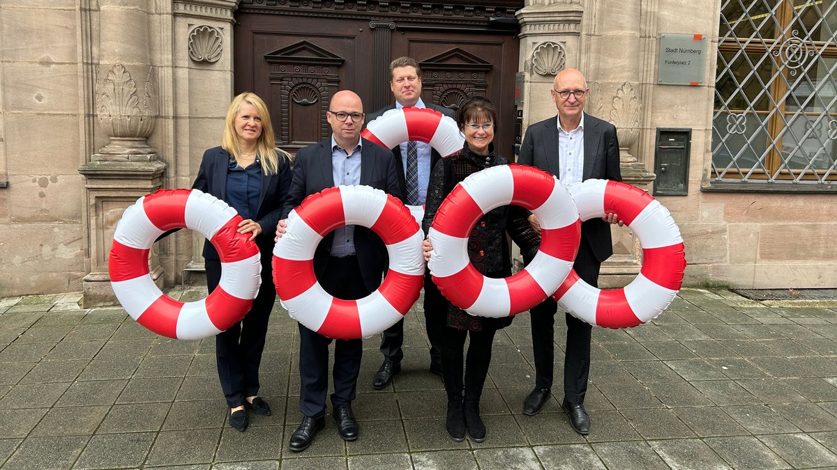 Die Kämmerer von Schwabach, Nürnberg, Ansbach, Fürth und Erlangen halten rot-weiß gestreifte Rettungsringe in die Höhe. Sie fordern Hilfe von Bund und Land.