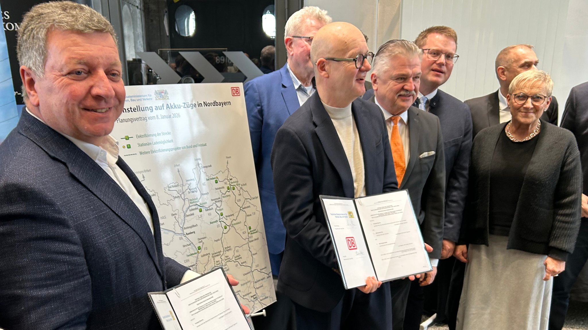 Die Dieselzüge in Nordbayern sollen bis zum Jahr 2040 ausrangiert werden. Stattdessen sollen elektrische Hybrid-Triebzüge zum Einsatz kommen. Am Donnerstag haben Bayerns Verkehrsminister Christian Bernreiter (CSU) und der Konzernbeauftragte der Deutschen Bahn (DB) für Bayern, Heiko Büttner, in Neuenmarkt im Landkreis Kulmbach dazu einen entsprechenden Vertrag unterzeichnet. | Bild: BR/Markus Feulner Die Dieselzüge in Nordbayern sollen bis zum Jahr 2040 ausrangiert werden. Stattdessen sollen elektrische Hybrid-Triebzüge zum Einsatz kommen. Am Donnerstag haben Bayerns Verkehrsminister Christian Bernreiter (CSU) und der Konzernbeauftragte der Deutschen Bahn (DB) für Bayern, Heiko Büttner, in Neuenmarkt im Landkreis Kulmbach dazu einen entsprechenden Vertrag unterzeichnet.