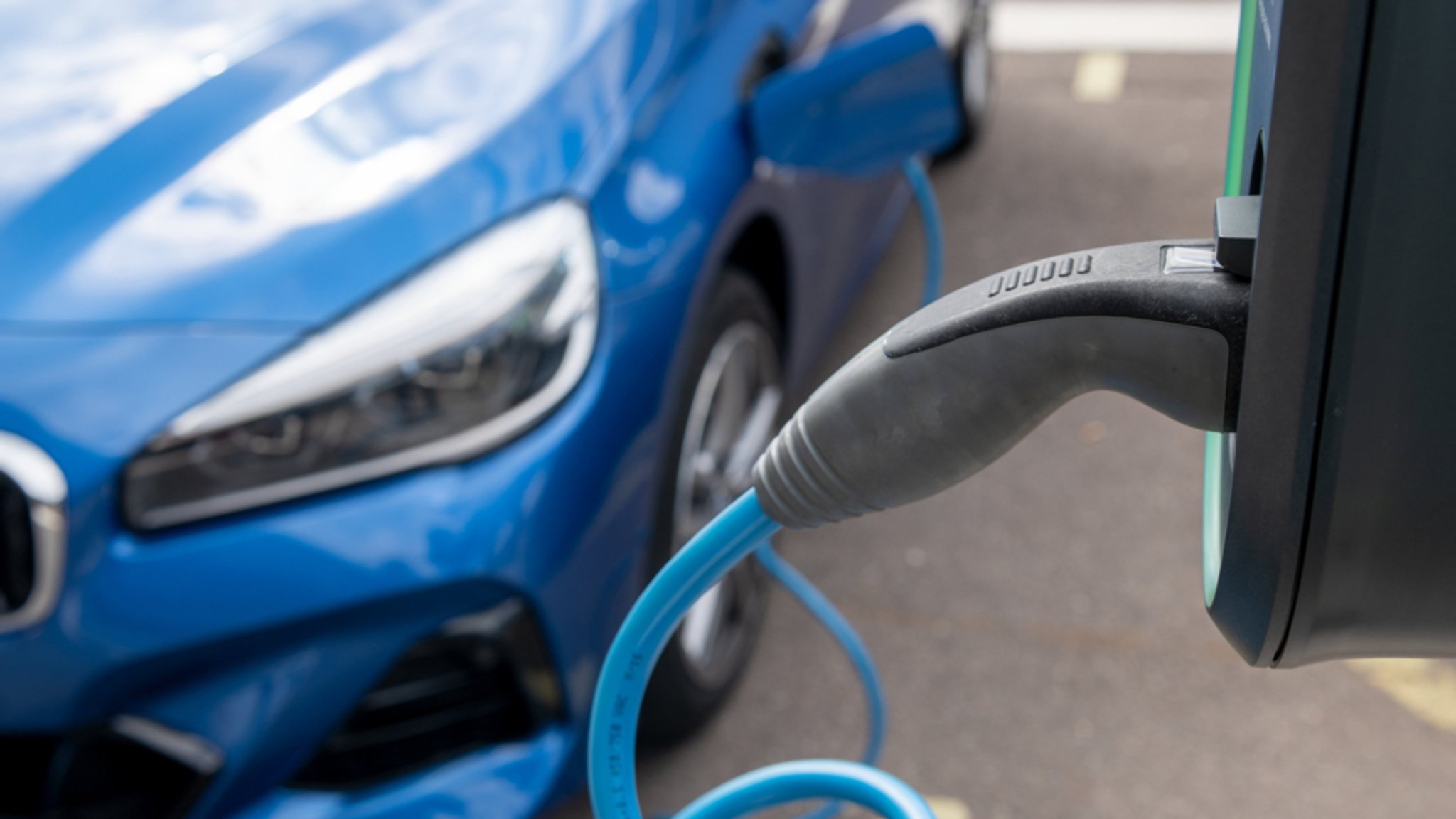 Ein Elektroauto wird auf einem Parkplatz geladen.