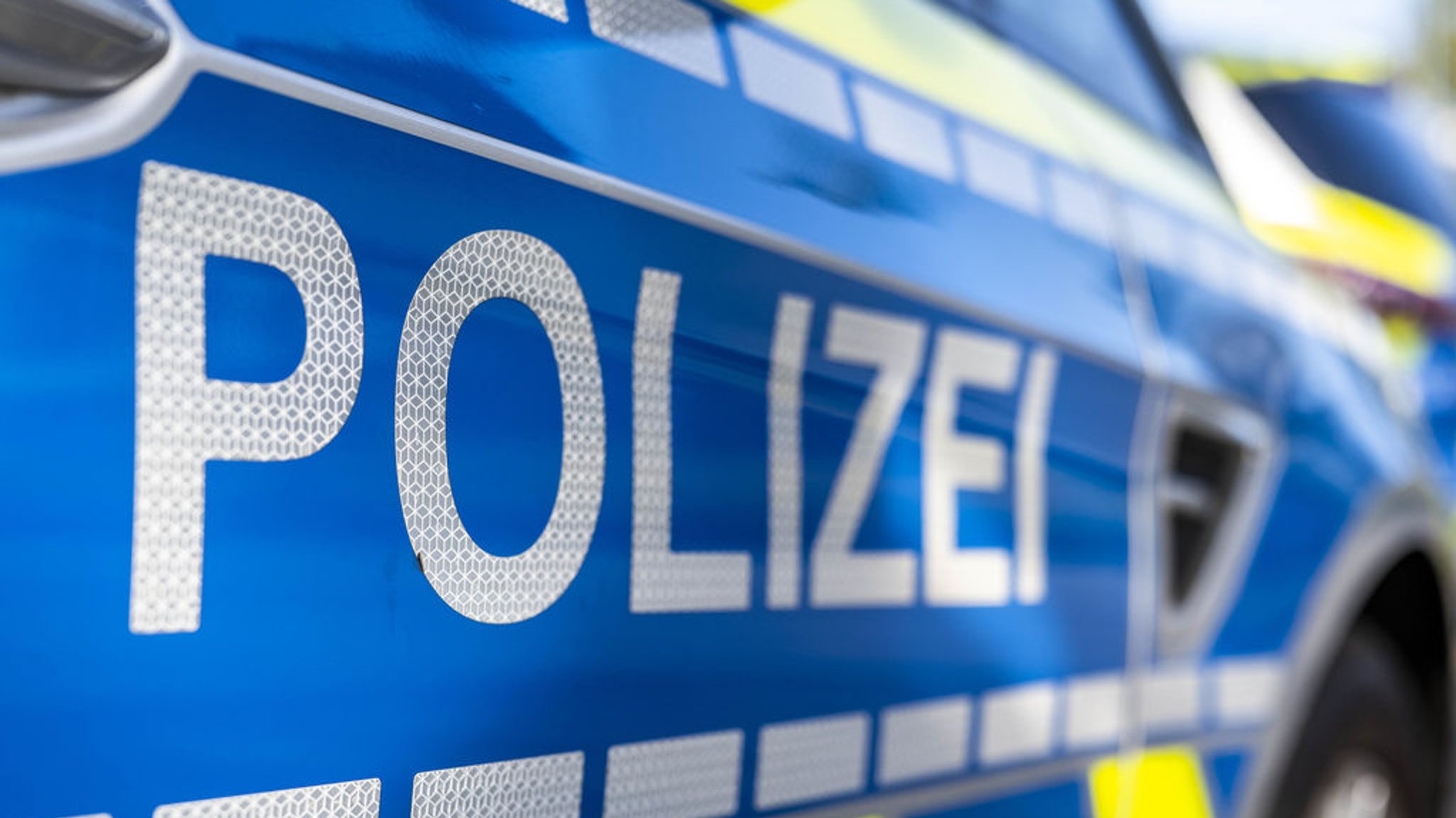 ILLUSTRATION - 28.09.2021, Nordrhein-Westfalen, Gütersloh: An der Tür von einem Streifenwagen steht der Schriftzug «Polizei». (zu dpa: «Mann bestellt Essen und raubt Auslieferungsfahrer aus - U-Haft») Foto: David Inderlied/dpa +++ dpa-Bildfunk +++