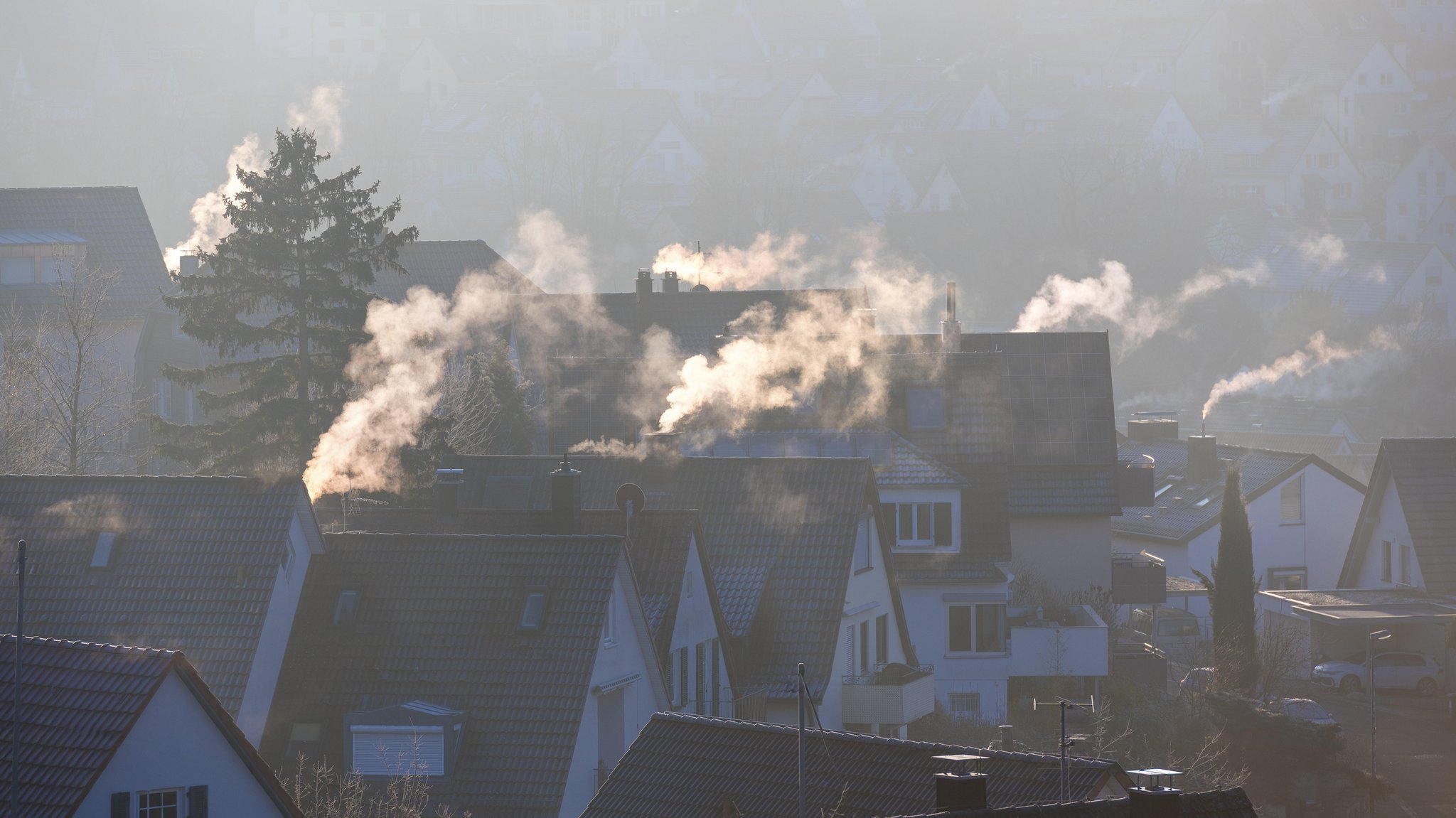 Ruhige Dorfansicht mit rauchenden Schornsteinen im morgendlichen Winterlicht, Symbolbild, Kamine, Gasheizung, Ölheizung, Holzheizung, Fossile Brennstoffe, Klimawandel, Klimaerwärmung, Schornsteine, Baden-Württemberg, Deutschland