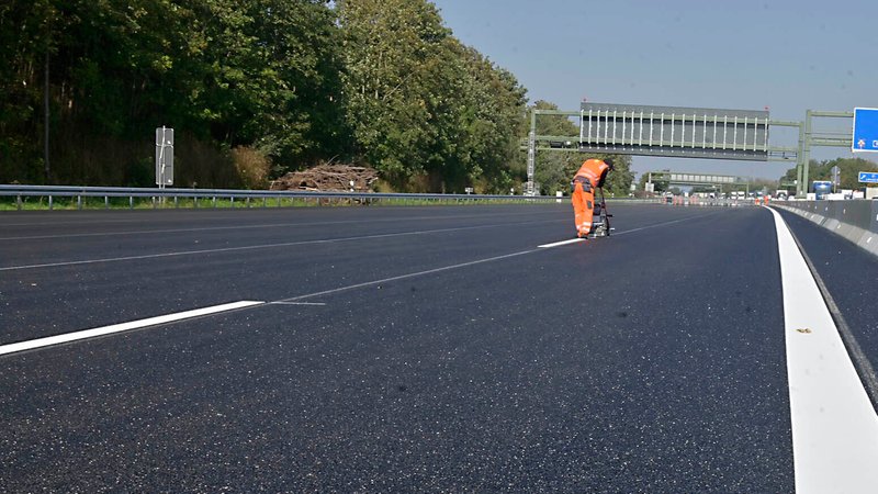 Ein Straßenbaumitarbeiter markiert auf einer Autobahn. | Bild: pa/SZ Photo | Claus Schunk Ein Straßenbaumitarbeiter markiert auf einer Autobahn.