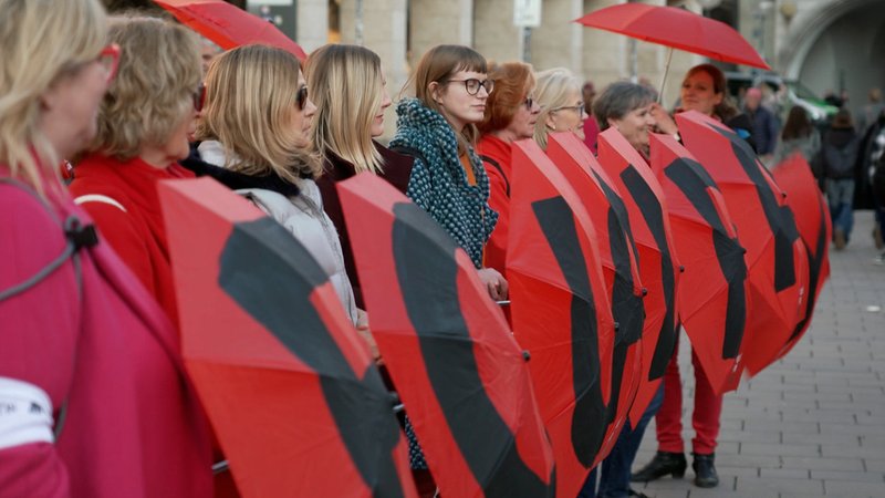 Auf dem Münchner Marienplatz hat heute ein Aktionsbündnis mit roten Schirmen für die Gleichberechtigung von Frauen und Männern bei der Bezahlung demonstriert. | Bild: BR Auf dem Münchner Marienplatz hat heute ein Aktionsbündnis mit roten Schirmen für die Gleichberechtigung von Frauen und Männern bei der Bezahlung demonstriert.
