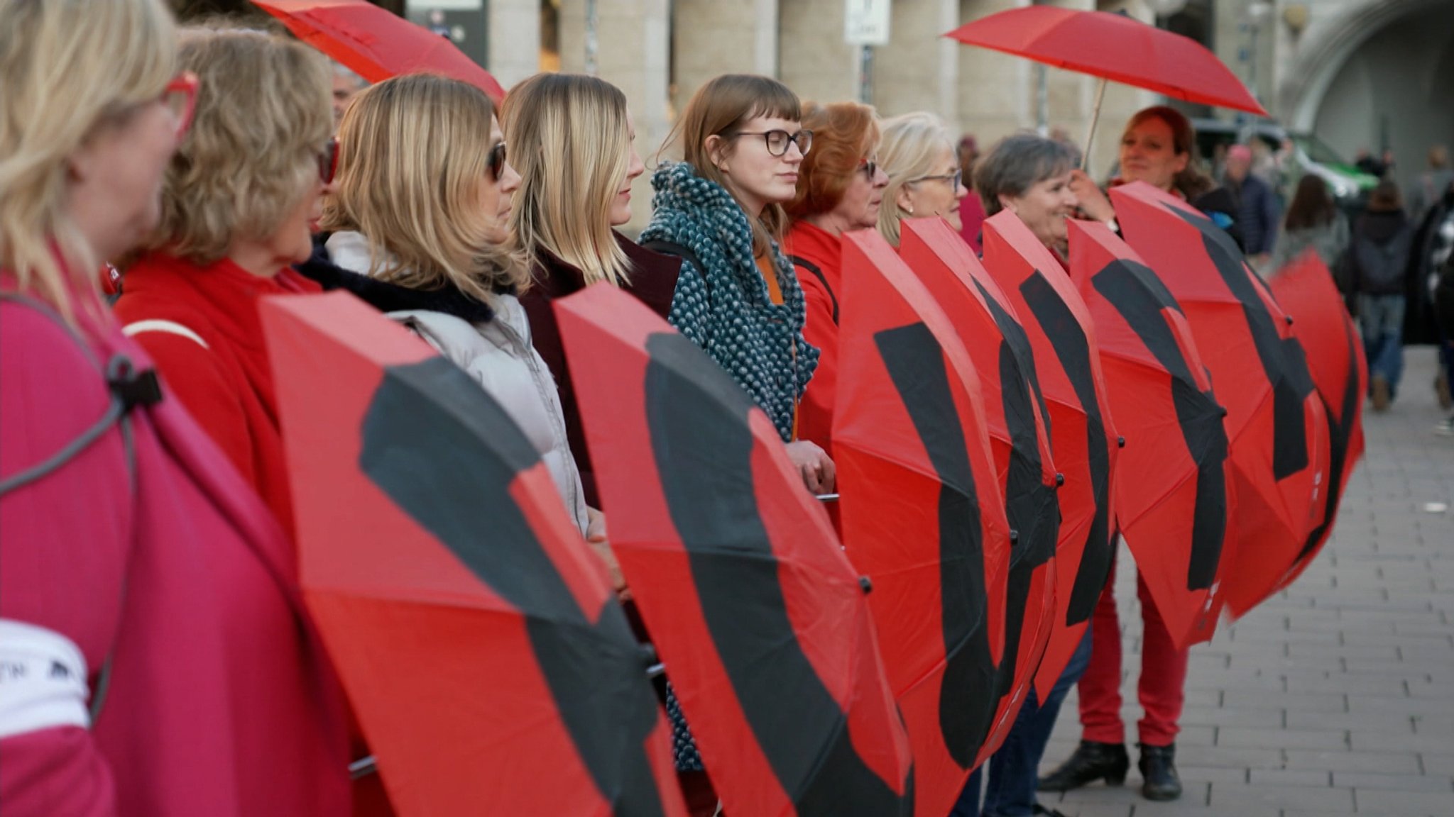 Auf dem Münchner Marienplatz hat heute ein Aktionsbündnis mit roten Schirmen für die Gleichberechtigung von Frauen und Männern bei der Bezahlung demonstriert.