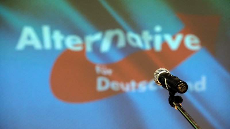 Ein Mikrofon steht beim Landesparteitag der der sächsischen AfD auf der Bühne vor dme Partei-Logo. | Bild: picture alliance/dpa | Sebastian Willnow Ein Mikrofon steht beim Landesparteitag der der sächsischen AfD auf der Bühne vor dme Partei-Logo.