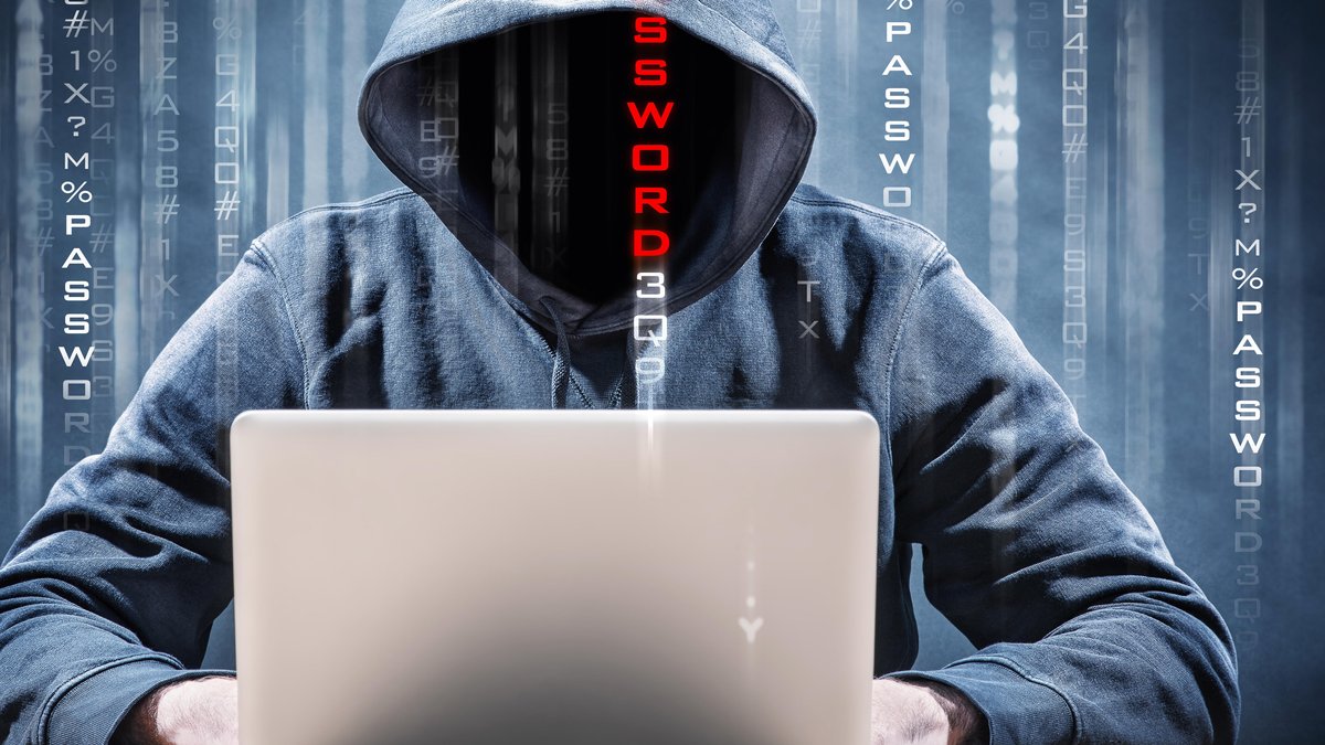 Hacker mit Kapuze sitzt vor Notebook 
