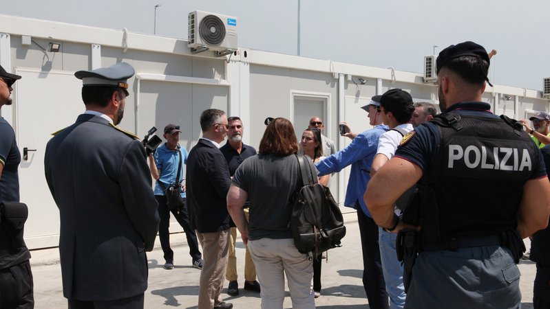 Fabrizio Bucci (3.v.l.), der Botschafter von Italien in Albanien, spricht mit Journalisten bei einem Informationsrundgang durch das sich im Bau befindliche Lager in Gjader. | Bild: picture alliance/dpa | Alketa Misja Fabrizio Bucci (3.v.l.), der Botschafter von Italien in Albanien, spricht mit Journalisten bei einem Informationsrundgang durch das sich im Bau befindliche Lager in Gjader.