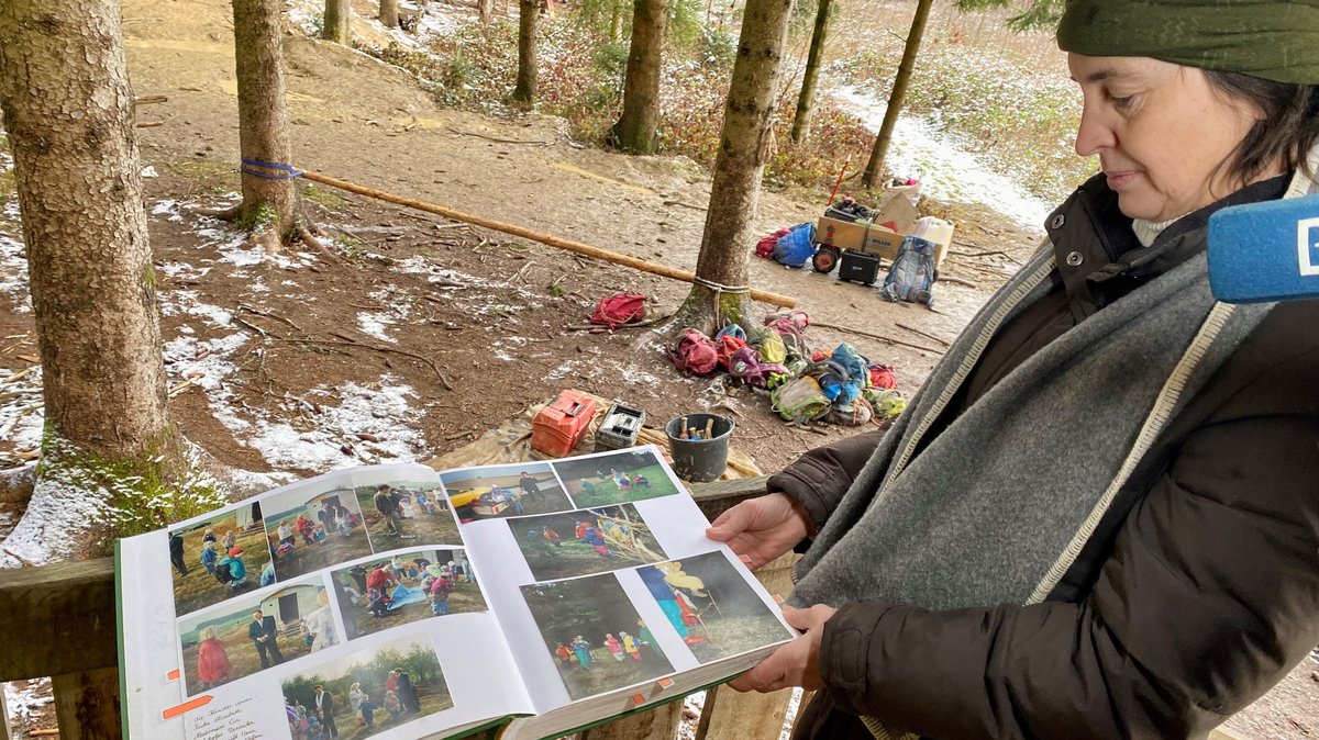 Initiatorin Eva Obermeier betrachtet Bilder von den Anfängen des Waldkindergartens