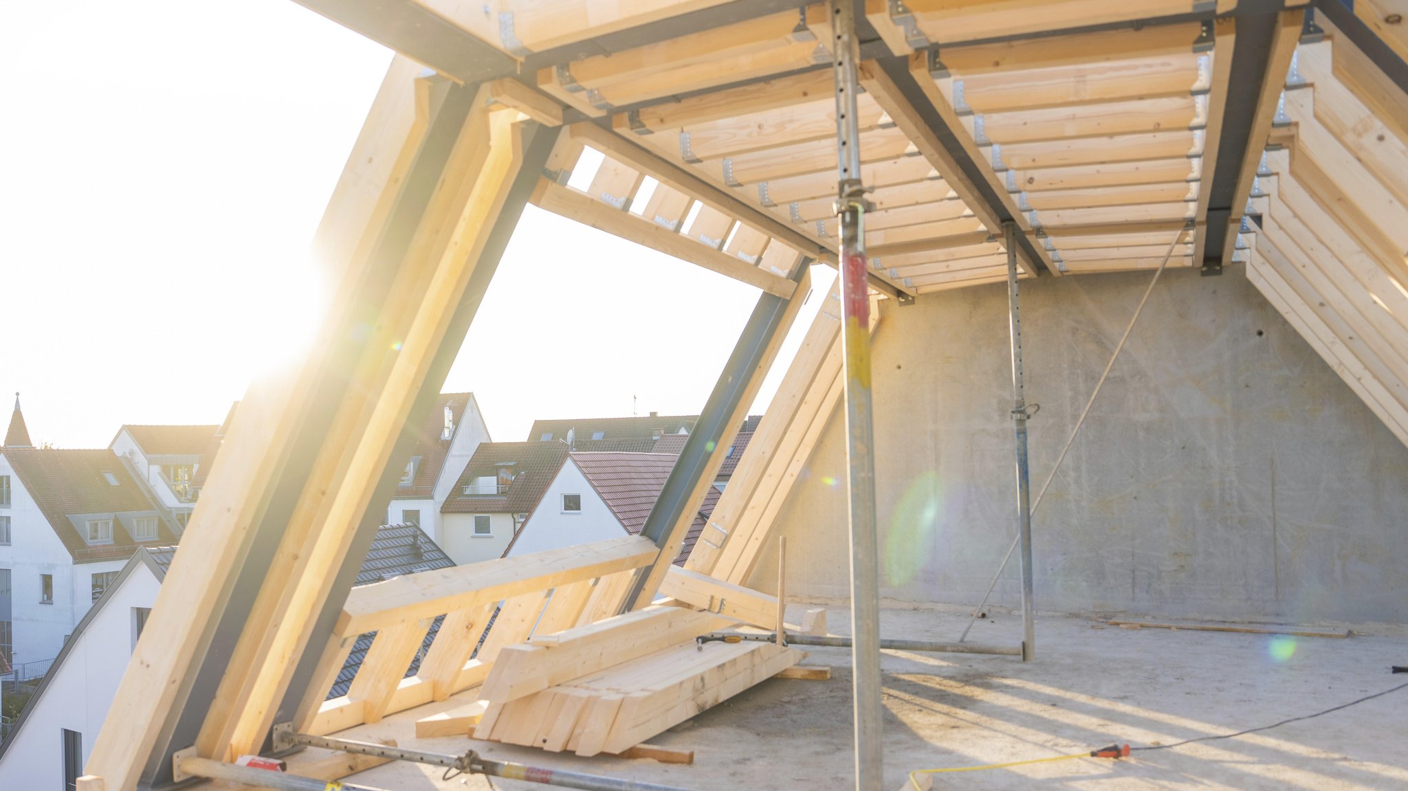 Symbolbild: Ein unvollendeter Dachstuhl mit Blick auf eine Siedlung. | Bild: picture alliance / imageBROKER | Manuel Kamuf Symbolbild: Ein unvollendeter Dachstuhl mit Blick auf eine Siedlung.