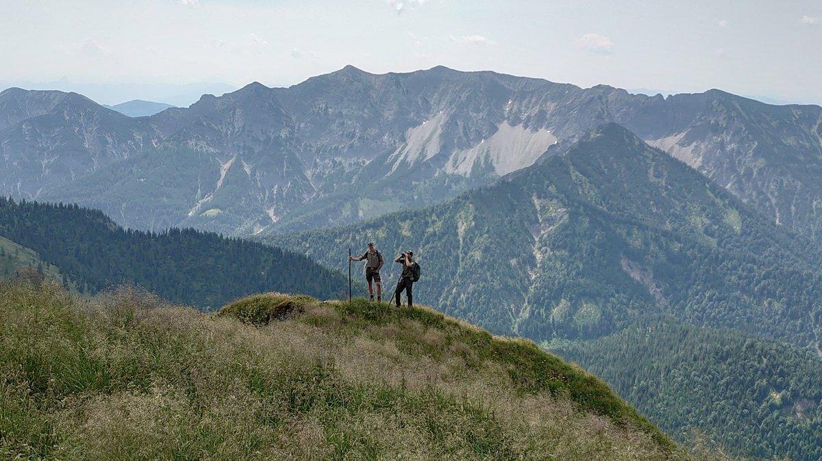 Zwei Ranger in Uniform stehen auf einer Kuppe in den Bergen